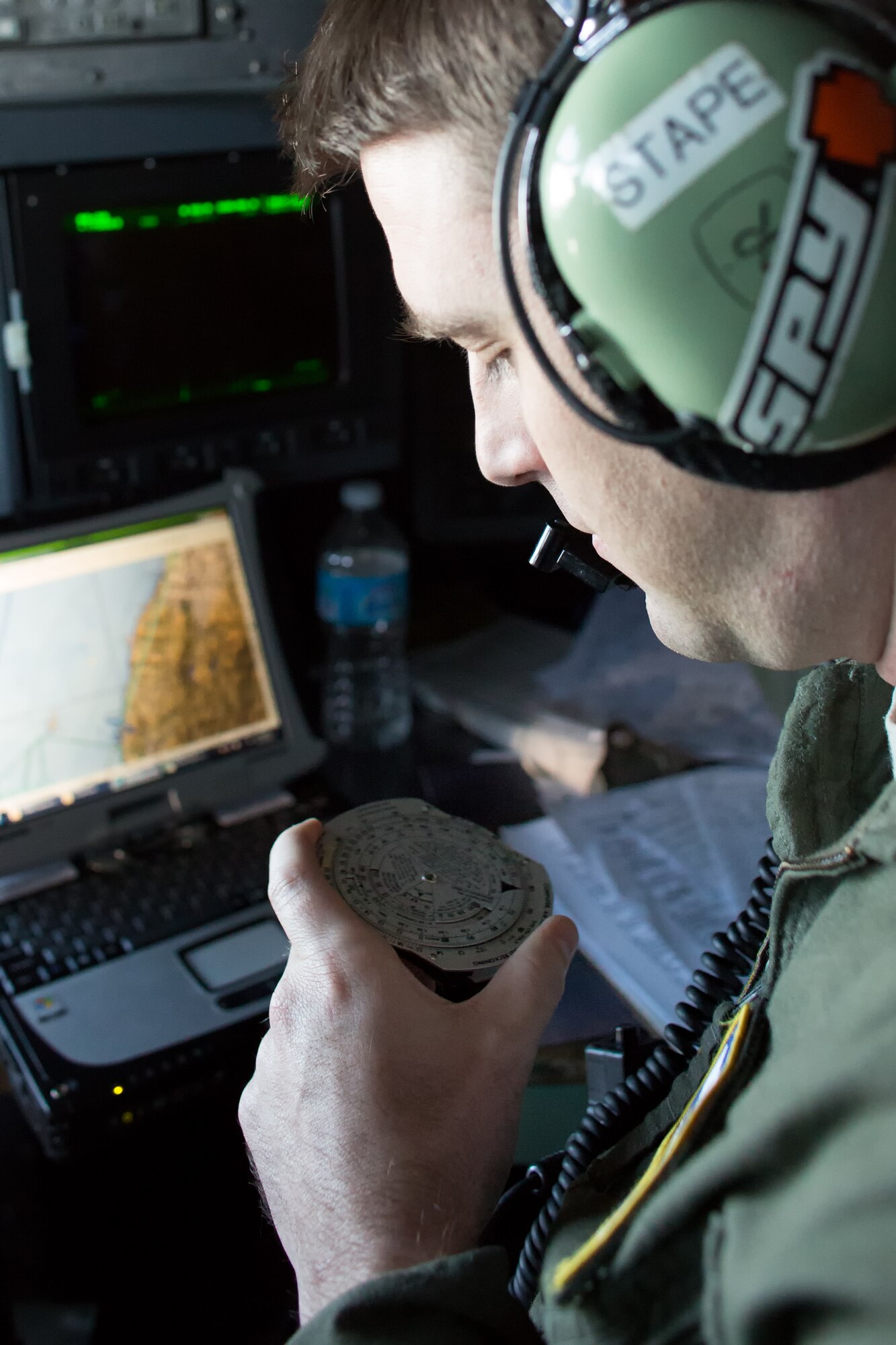 Capt. Christopher Stapenhorst, 36th Airlift Squadron navigator, uses the E6B Flight Computer, as known "Whiz wheel" to calculate ground speed, estimated fuel burn and updated estimated time of arrival in the air, Oct. 22, 2013.  (U.S. Air Force photo by Osakabe Yasuo/Released)
