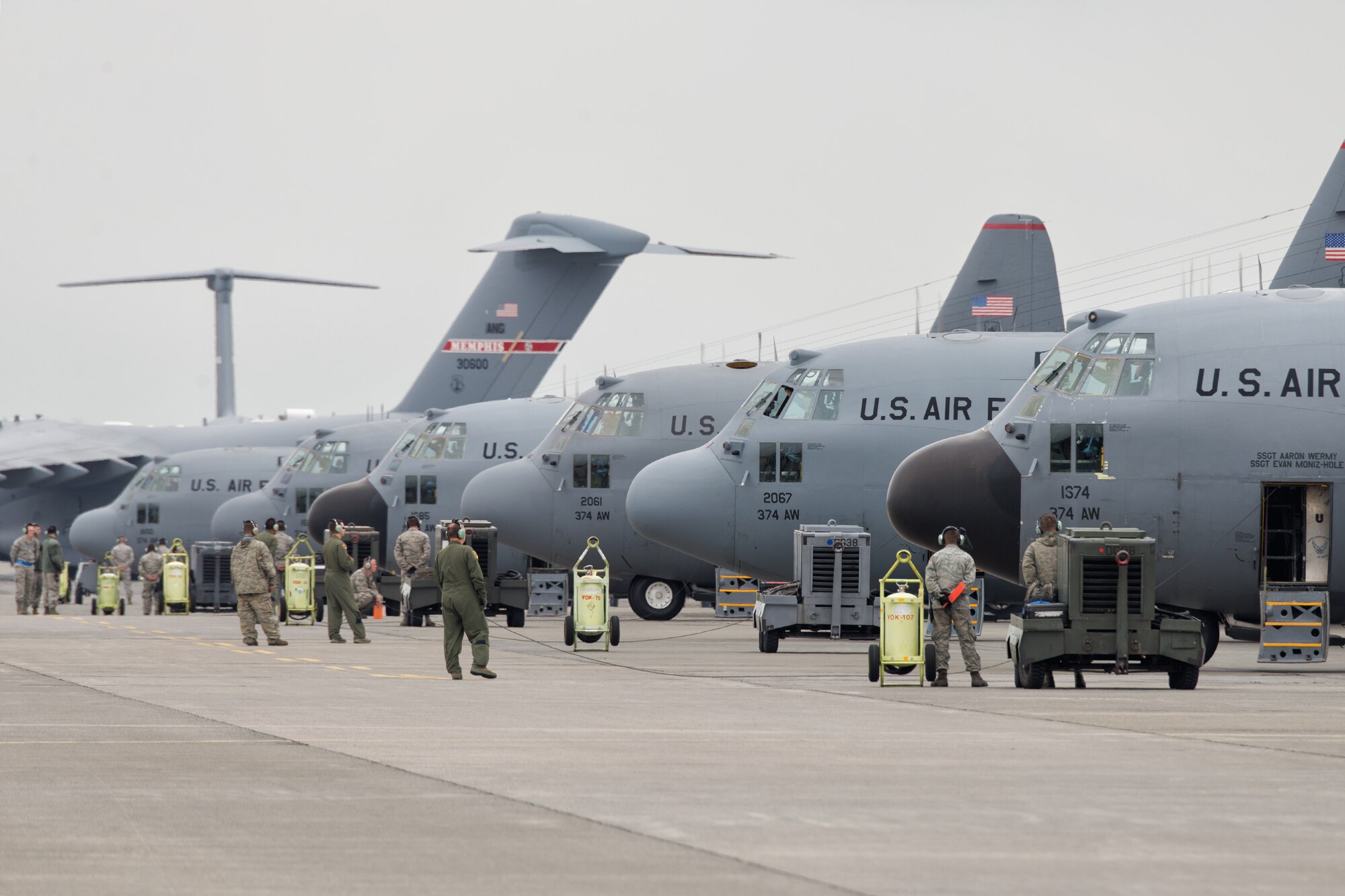 Crew chiefs and loadmasters perform a preflight inspection by a C-130 Hercules at Yokota Air Base, Japan, Oct. 22, 2013. Ten C-130 Hercules from the 36th Airlift Squadron participated in a large formation flight that tested Yokota's ability to perform large-force employment and tactics. (U.S. Air Force photo by Osakabe Yasuo/Released)