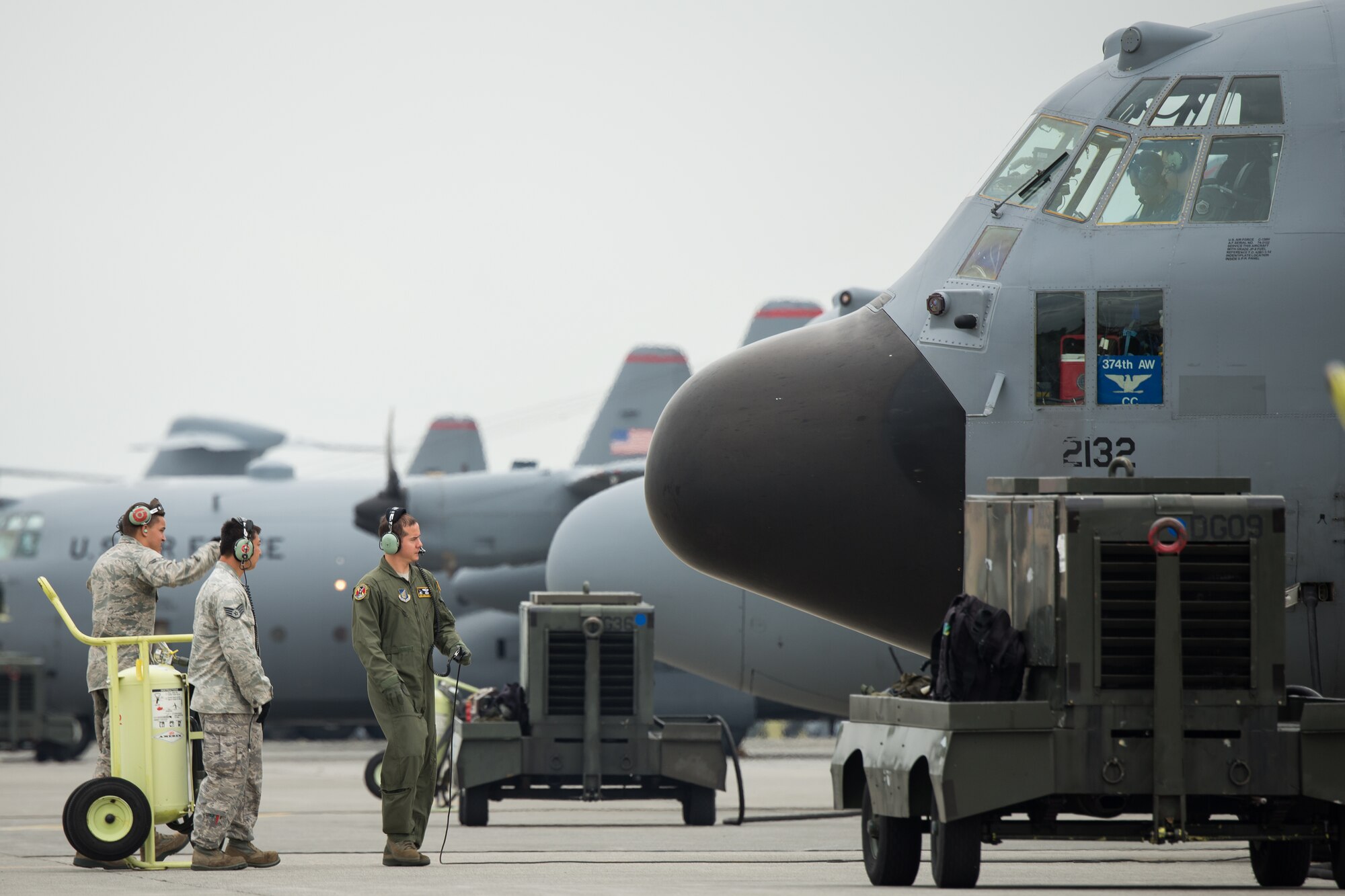 Airmen perform a preflight inspection by a C-130 Hercules at Yokota Air Base, Japan, Oct. 22, 2013. Ten C-130 Hercules from the 36th Airlift Squadron participated in a training sortie that tested Yokota's ability to perform large-force employment and tactics. (U.S. Air Force photo by Osakabe Yasuo/Released)
