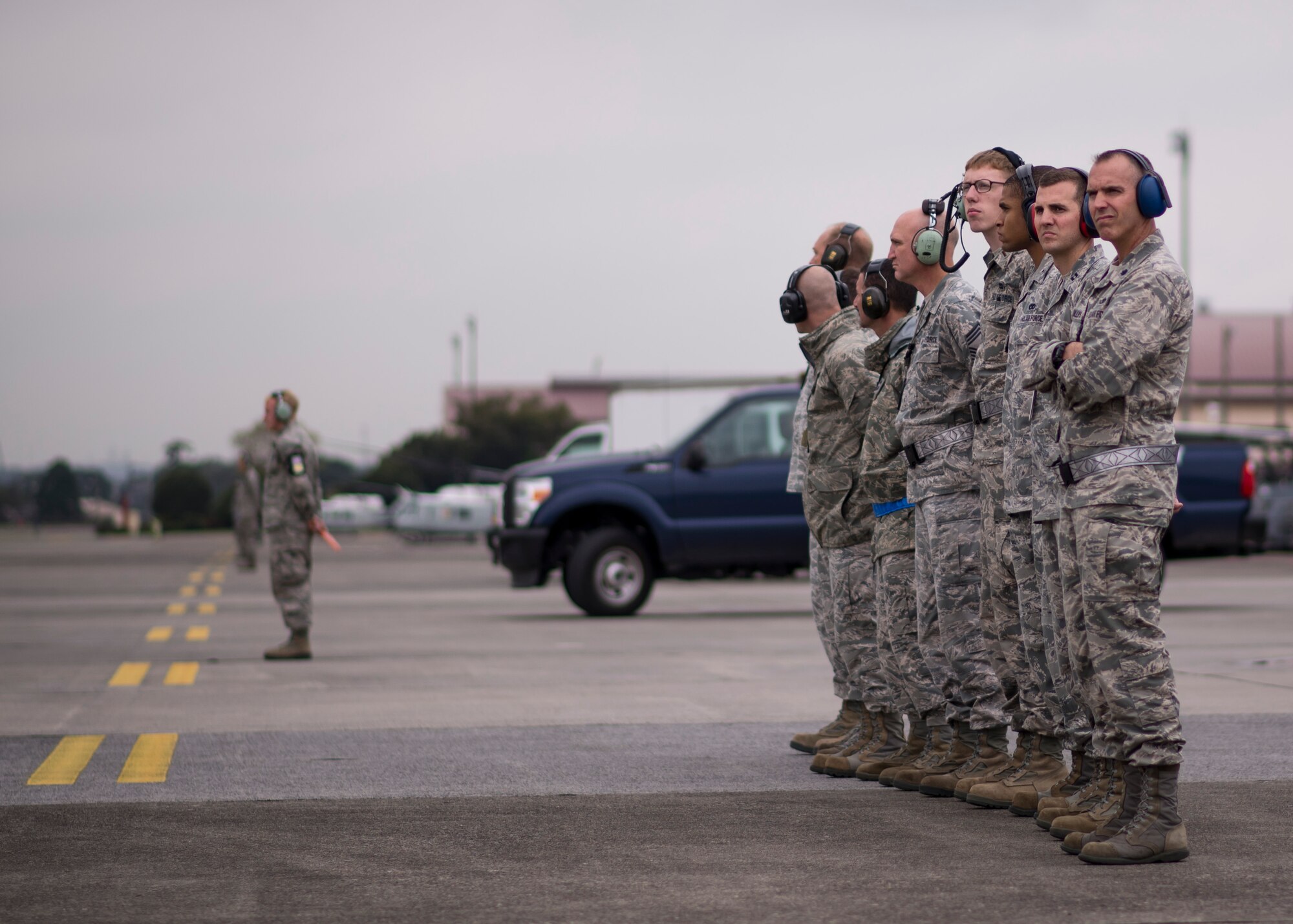 Airmen from the 374th Maintenance Group observe as 10 C-130 Hercules prepare to launch during a large-formation mission at Yokota Air Base, Japan, Oct. 22, 2013. Preparing a large formation requires the combined efforts of all Yokota Airmen, working in tandem to ensure aircraft and crews are prepared to provide support throughout the Pacific region. (U.S. Air Force photo by Captain Raymond Geoffroy/Released)