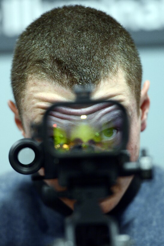 Virginia Military Institute Cadet Matthew Nielsen looks through a scope on a weapons display during the Association of the U.S. Army's annual meeting and exposition in Washington, D.C., Oct. 22, 2013.