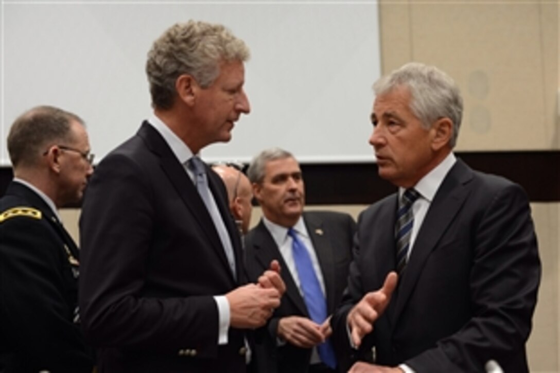 U.S. Defense Secretary Chuck Hagel, right, speaks with Belgian Defense Minister Pieter De Crem before a meeting of NATO and partner nations that contribute to the International Security Assistance Force at NATO headquarters in Brussels, Oct. 23, 2013. 