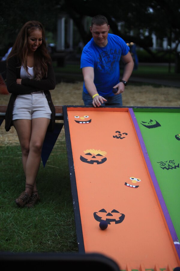 NEW ORLEANS – Cpl. Estephania de León, an administrative specialist with Marine Corps Individual Reserve Support Activity at Marine Forces Reserve, and Staff Sgt. Michael Milstead, the training chief for 4th Marine Division operations and training section, demonstrate a game for visitors at the Children’s Hospital, New Orleans’ annual fundraiser, Boo at the Zoo, Oct. 19, 2013. Marines from MARFORRES have supported various children’s hospital volunteer events in the past, such as visiting patients at the hospital or helping at fundraisers. (U.S Marine Corps photo by Lance Cpl. Tiffany Edwards)