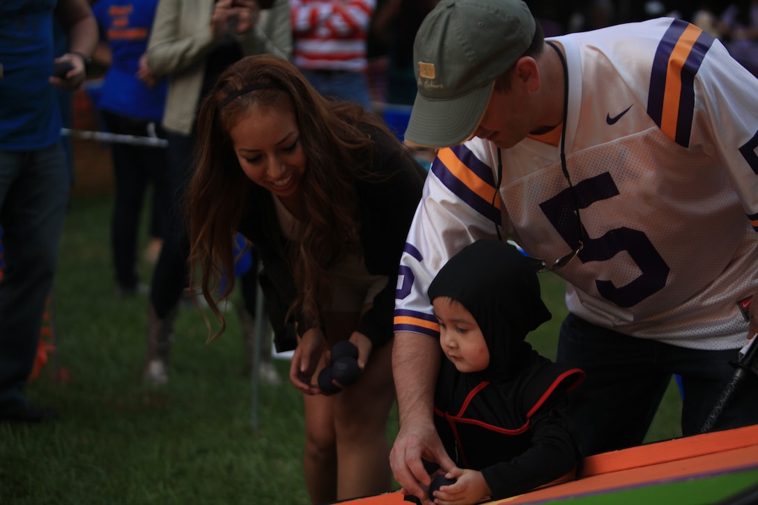 NEW ORLEANS – Cpl. Estephania de León, an administrative specialist with Marine Corps Individual Reserve Support Activity at Marine Forces Reserve, demonstrates a game for visitors at the Children’s Hospital, New Orleans’ annual fundraiser, Boo at the Zoo, Oct. 19, 2013. The event sold out for both of its Saturday events at the Audubon Zoo, hosting 5,000 visitors and roughly 400 volunteers each night. (U.S Marine Corps photo by Lance Cpl. Tiffany Edwards)