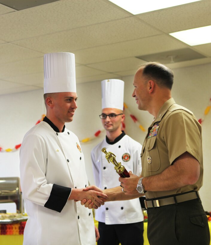 Lance Cpl.  Zachery C. Schram receives the 1st place award from Col. Chris Pappas III, the commanding officer of Marine Corps Air Station Cherry Point during the Chef of the Year competition Oct. 18.