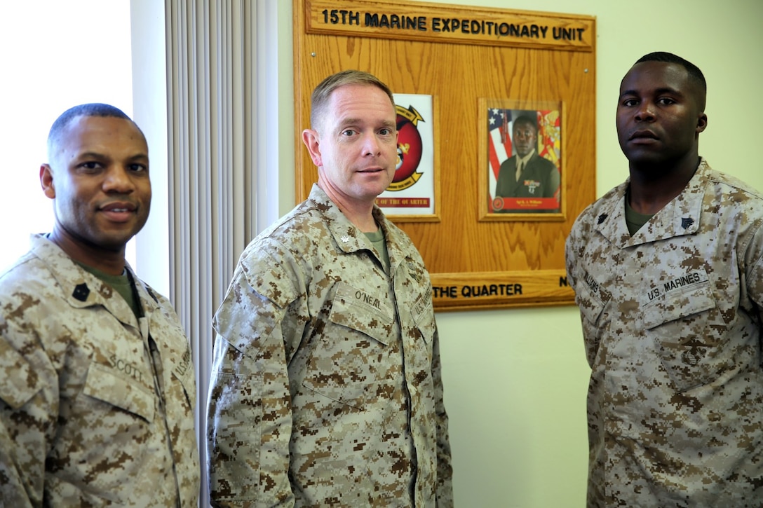Sergeant Maj. John W. Scott, left, sergeant major, 15th Marine Expeditionary Unit, and Lt. Col. John O'Neal, commanding officer, 15th MEU, recognize Sgt. Kenton A. Williams, motor transportation chief, 15th MEU, as the 15th MEU's Non Commissioned Officer of the Quarter aboard Camp Pendleton, Calif., Oct. 23, 2013. Williams, born in Jamaica and raised in Aurora, Colo., joined the Marine Corps in July of 2006. (U.S. Marine Corps photo by Staff Sgt. Miguel Carrasco/Released)