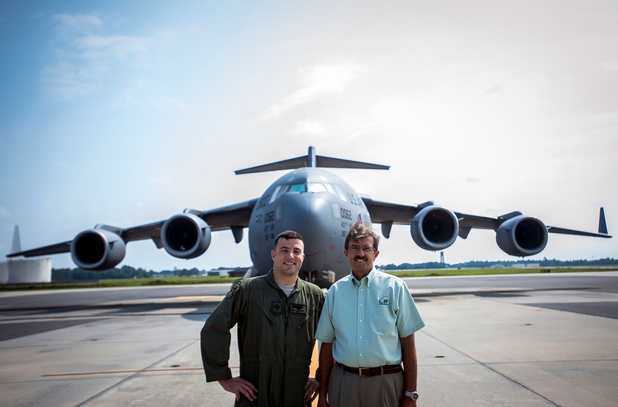 Tech. Sgt. Mike Morris, 437th Airlift Wing Operations Group standards and evaluations loadmaster, enjoys a stroll on the flight line with his father, ret. Chief Master Sgt. Bob Morris, C-17 Training Systems Charleston lead loadmaster, Sept. 17, 2013 at Joint Base Charleston – Air Base, S.C. Bob is a retired loadmaster and was on the plane for the arrival of the first C-17 delivered to the Air Force in June 1993.