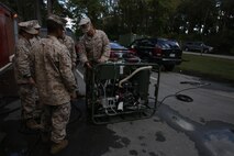 Lance Cpl. Brian K. Wightman (right), a chemical, biological, radiological and nuclear defense specialist with CBRN Platoon, Combat Logistics Regiment 27, 2nd Marine Logistics Group discusses start-up procedures of the M26 Joint Service Transportable Decontamination System with service members with 2nd MLG during a CBRN decontamination course aboard Camp Lejeune, N.C., Oct. 23, 2013. Students attending the week-long course learn a variety of CBRN defense and decontamination procedures to provide assistance in the event of a CBRN attack.