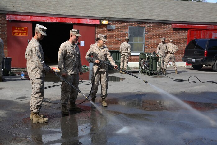 Pfc. Taren C. Seidel (right), a water support technician with 8th Engineer Support Battalion, 2nd Marine Logistics Group, and Lance Cpl. Michelle E. Rusz (right), an administration specialist with Combat Logistics Regiment 27, 2nd MLG, demonstrate the spray capabilities of the M26 Joint Service Transportable Decontamination System during a chemical, biological, radiological and nuclear decontamination course aboard Camp Lejeune, N.C., Oct. 23, 2013. The M26 was designed to be lightweight and have the ability to decontaminate personnel, equipment and vehicles from CBRN agents. 