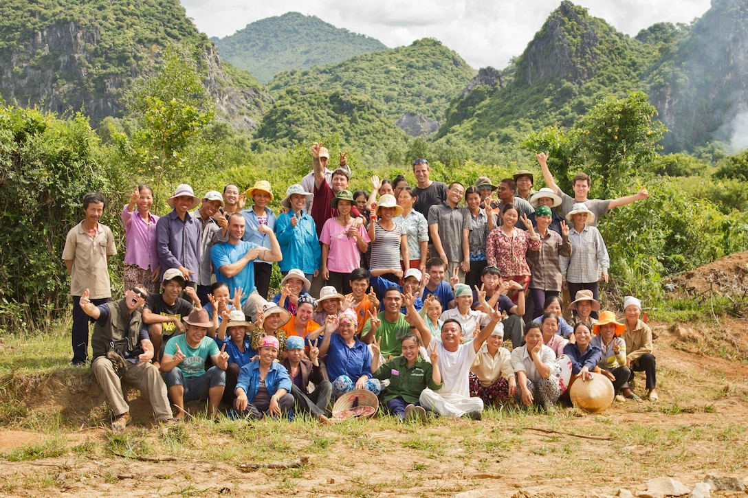 Members of a Joint POW/MIA Accounting Command team pose for a photo with local workers during a JPAC mission in Vietnam, Aug. 28, 2013. Staff Sgt. Thomas H. Nguyen, explosive ordnance disposal technician, 1st Explosive Ordnance Disposal Company, 7th Engineer Support Battalion, Combat Logistics Regiment 1, 1st Marine Logistics Group, was a member of the team and swept excavation sites for unexploded ordnance. 