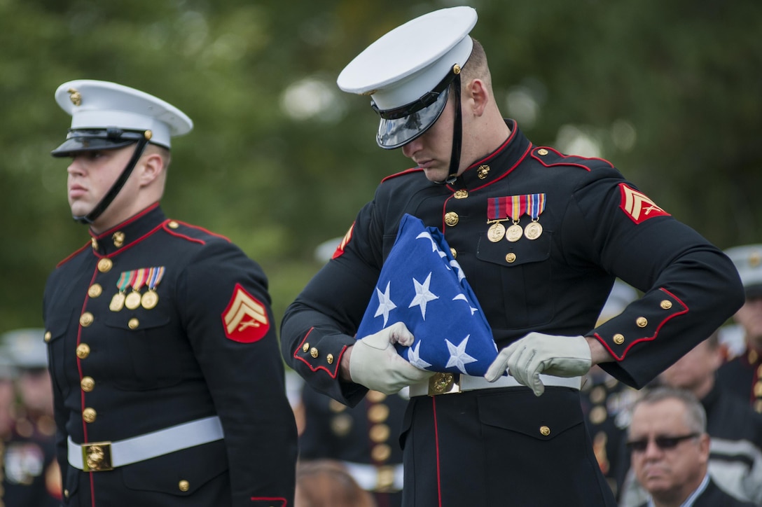 Cpl. Ruben Franco, Marine Barracks Washington D.C. body bearer, finishes folding a flag during a funeral ceremony at Arlington National Cemetery Oct. 24. The ceremony, supported by the Barracks, was held for a group of six Marines who died in a CH-53 helicopter crash in Afghanistan on January 19, 2012. The deceased are Capt. Daniel Bartle, Capt. Nathan McHone, Master Sgt. Travis Riddick, Cpl. Jesse Stites, Cpl. Kevin Reinhard and Cpl. Joseph Logan.