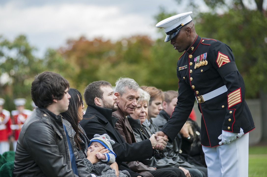 Master Sgt. Leonard Spain, Marine Barracks Washington D.C. funeral director, shakes hands with family members of the deceased during a funeral ceremony at Arlington National Cemetery Oct. 24. The ceremony, supported by the Barracks, was held for a group of six Marines who died in a CH-53 helicopter crash in Afghanistan on January 19, 2012. The deceased are Capt. Daniel Bartle, Capt. Nathan McHone, Master Sgt. Travis Riddick, Cpl. Jesse Stites, Cpl. Kevin Reinhard and Cpl. Joseph Logan.