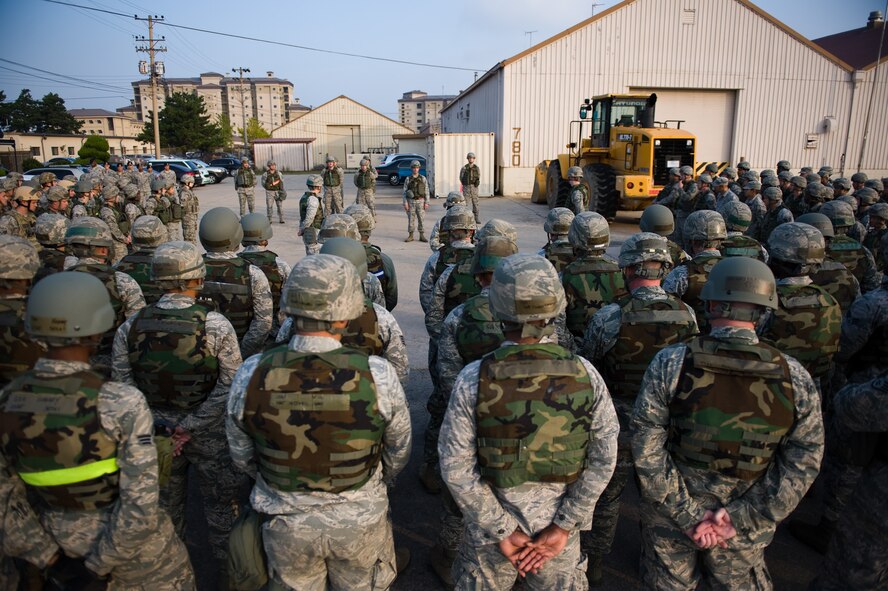 Lt. Col. Frank Hughes, 8th Civil Engineer Squadron commander, middle, speaks to his squadron before the beginning of the squadron’s readiness training day at Kunsan Air Base, Republic of Korea, Oct. 24, 2013. Airmen from the 8th CES trained with the 8th Security Forces Squadron on how to defend their compound. The 8th SFS trained the Red Devils on communication tactics, apprehending suspects and manning defensive positions. (U.S. Air Force photo by Senior Airman Armando A. Schwier-Morales/Released)