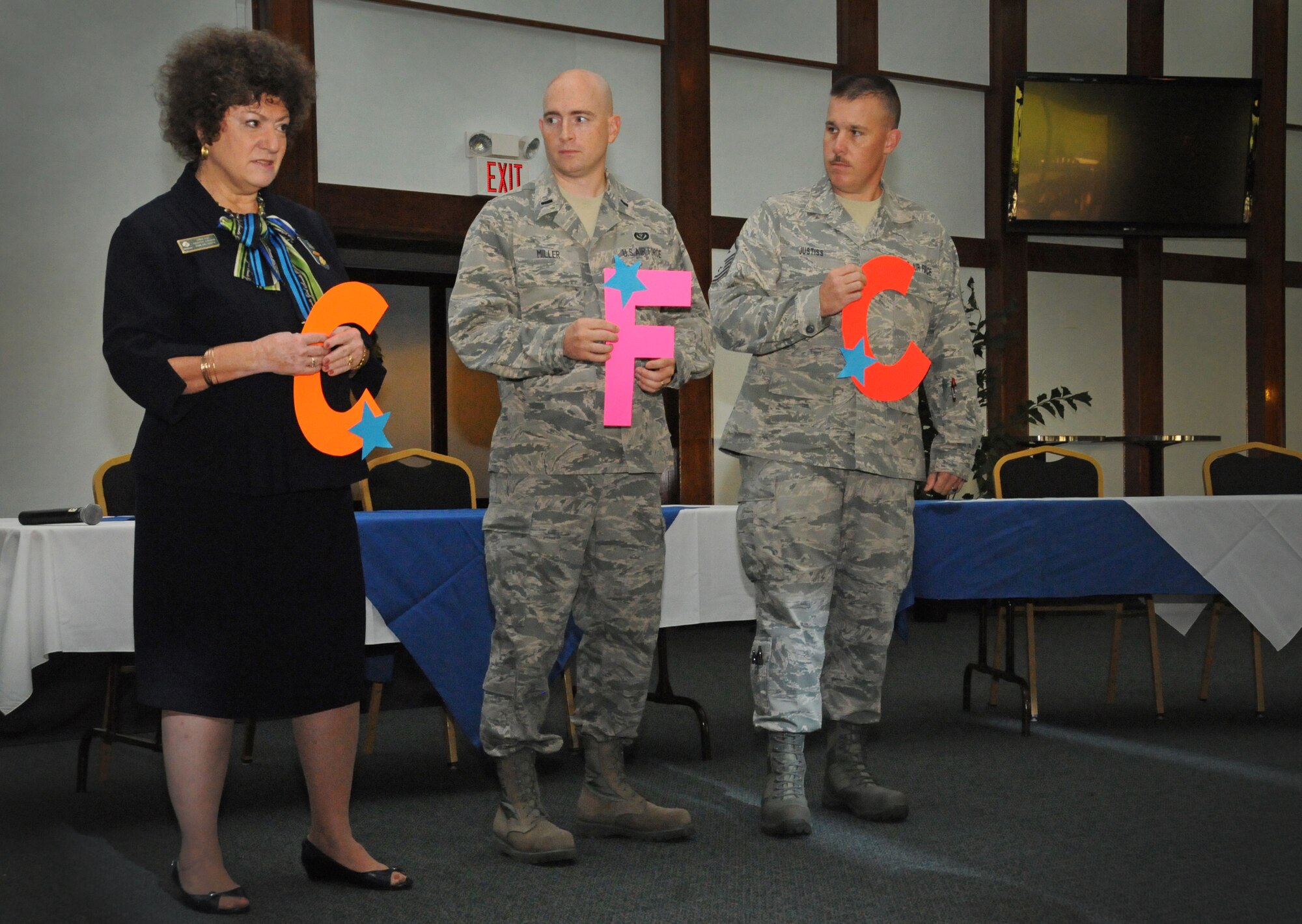 Vickie Fish, Guam Girl Scouts executive director, 1st Lt. Jeremy Miller 554th RED HORSE squadron project engineer, and Master Sgt. David Justiss, 554th RED HORSE Squadron first sergeant, hold up letters during a Combined Federal Campaign presentation Sept. 26, 2013 on Andersen Air Force Base, Guam. The presentation educated Airmen about the CFC program and informed them of volunteer opportunities and local charities they can contribute to. This year’s CFC program runs through Oct. 31. Anyone who would like to donate should contact one of their unit’s key workers. (U.S. Air Force photo by Airman 1st Class Amanda Morris/Released)