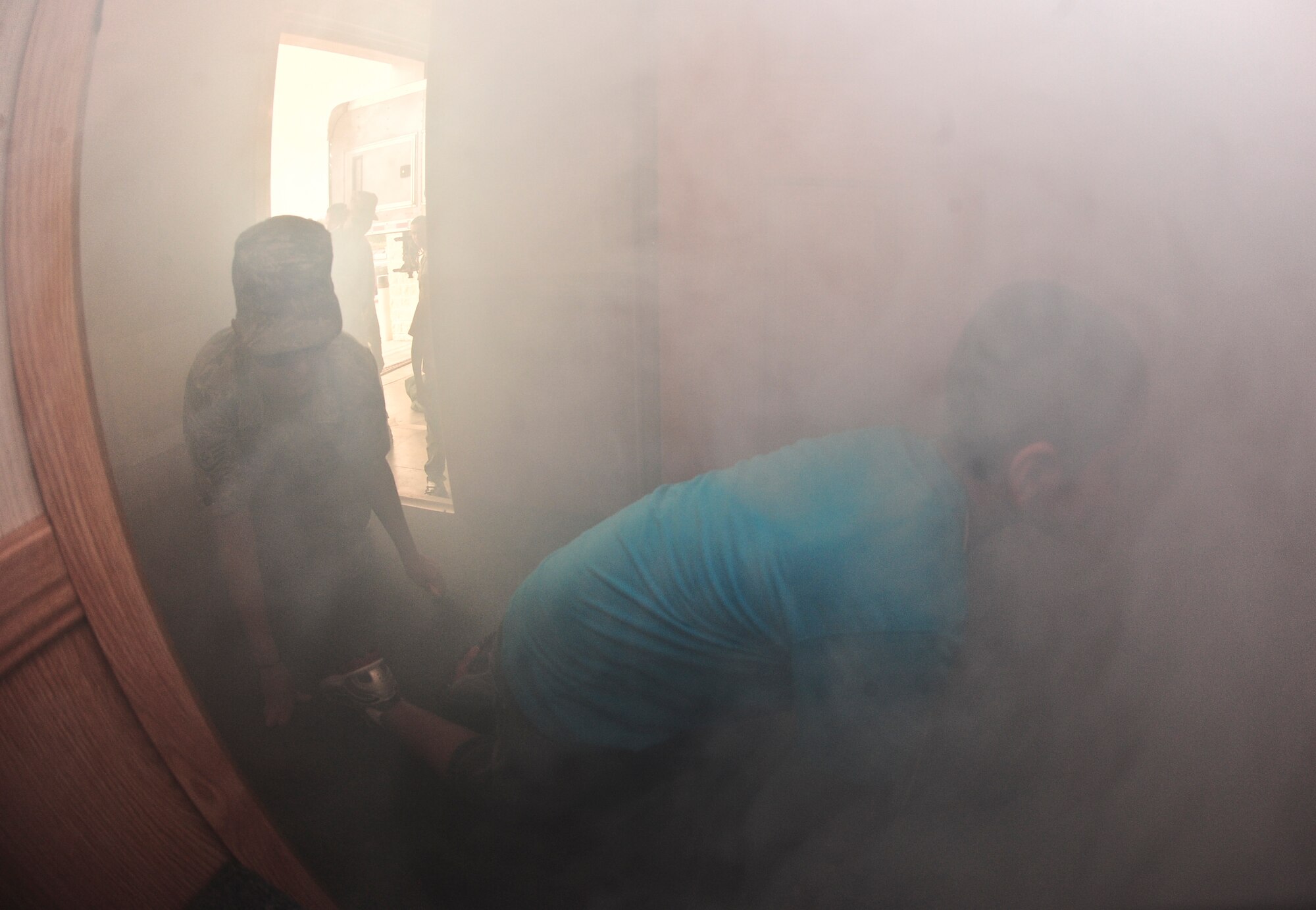 Littles and their Bigs crawl through a smoking house simulator Oct. 21, 2013, during Bigs for a Day at the crash fire station on MacDill Air Force Base, Fla. Approximately one hundred youth (Littles) from the local community were paired up with military members (Bigs) and toured various locations around MacDill AFB. (U.S. Air Force photo by Senior Airman Michael Ellis/Released)