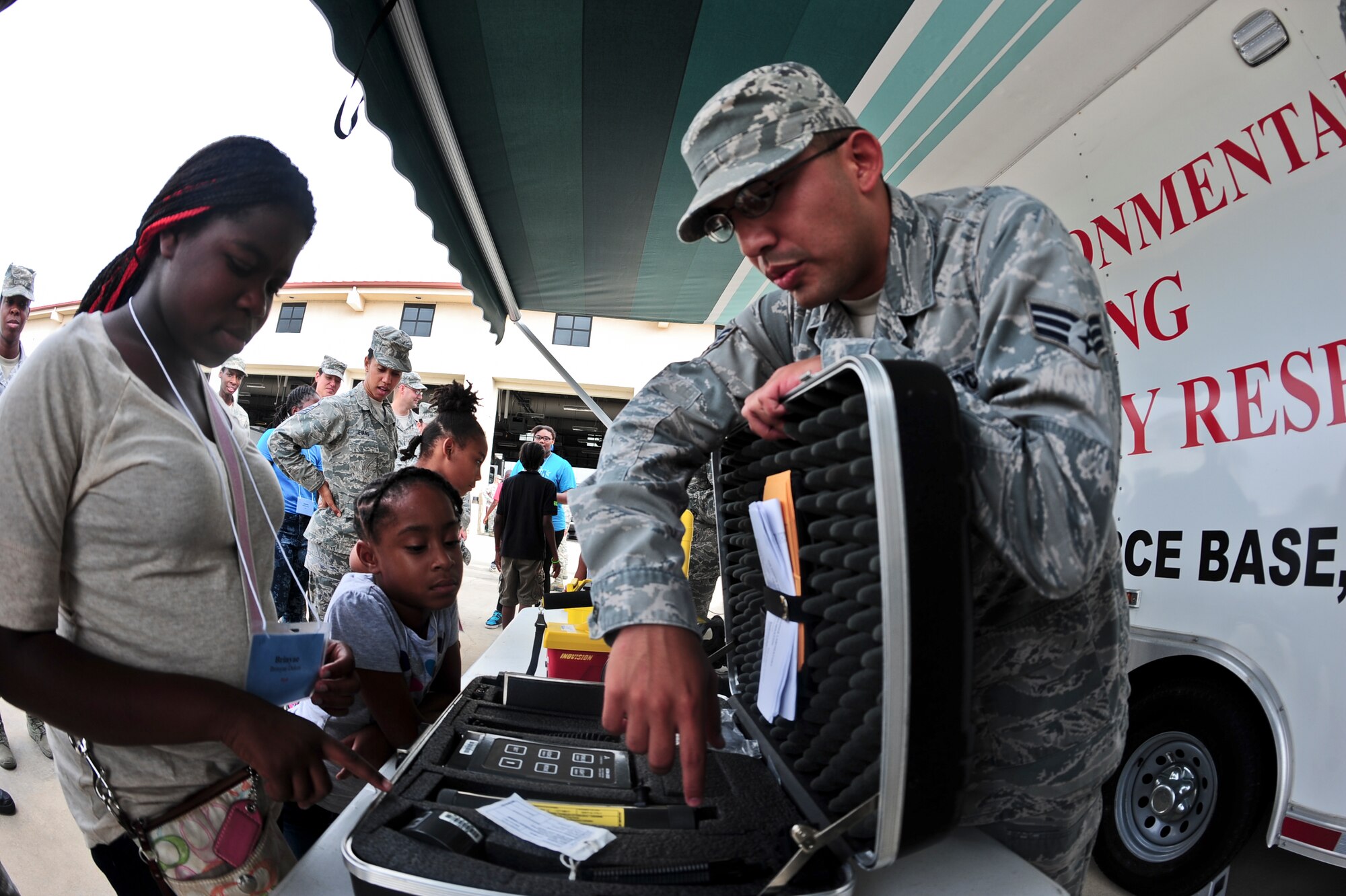 Senior Airman Hector Mendez-Chavez, 6th Aerospace Medicine Squadron bioenvironmental flight, explains the various equipment that would be used in an emergency response situation Oct. 21, 2013, during Bigs for a Day at MacDill Air Force, Fla. Approximately one hundred youth (Littles) were paired up with military members (Bigs) and toured various locations around MacDill AFB. (U.S. Air Force photo by Senior Airman Michael Ellis/Released)