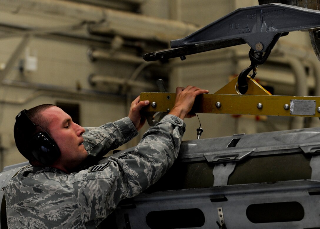 Staff Sgt. Eric Czaplinski, 34th Aircraft Maintenance Unit weapons load crew team chief, stabilizes the transfer of a mock guided bomb unit during the third quarter load crew competition at Ellsworth Air Force Base, S.D., Oct. 18, 2013. During the competition’s team selection process, Airmen were evaluated on how quickly they loaded munitions according to established procedures and standards. (U.S. Air Force photo by Senior Airman Anania Tekurio/Released)