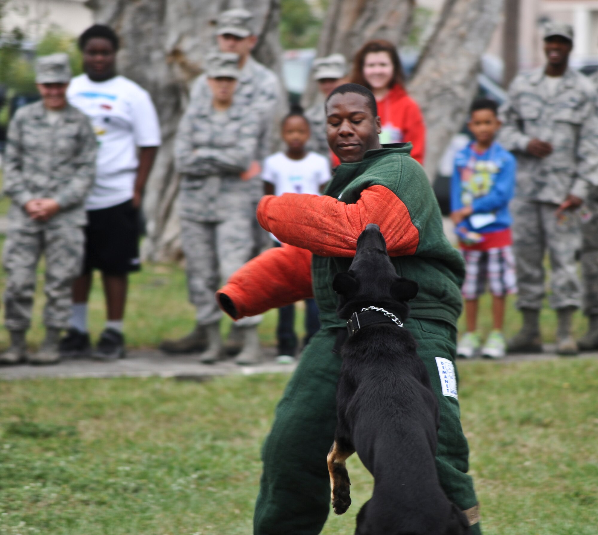 Staff Sgt. Marcus Dawson, 6th Security Forces Squadron militay working dogs handler, and K-9 Dagi perform a suspect bite scenario Oct. 21, 2013, during Bigs for a Day at MacDill Air Force Base, Fla. Approximately one hundred local youth (Littles) were paired up with military members (Bigs) and toured various locations around MacDill AFB. (U.S. Air Force photo by Senior Airman Michael Ellis/Released)  