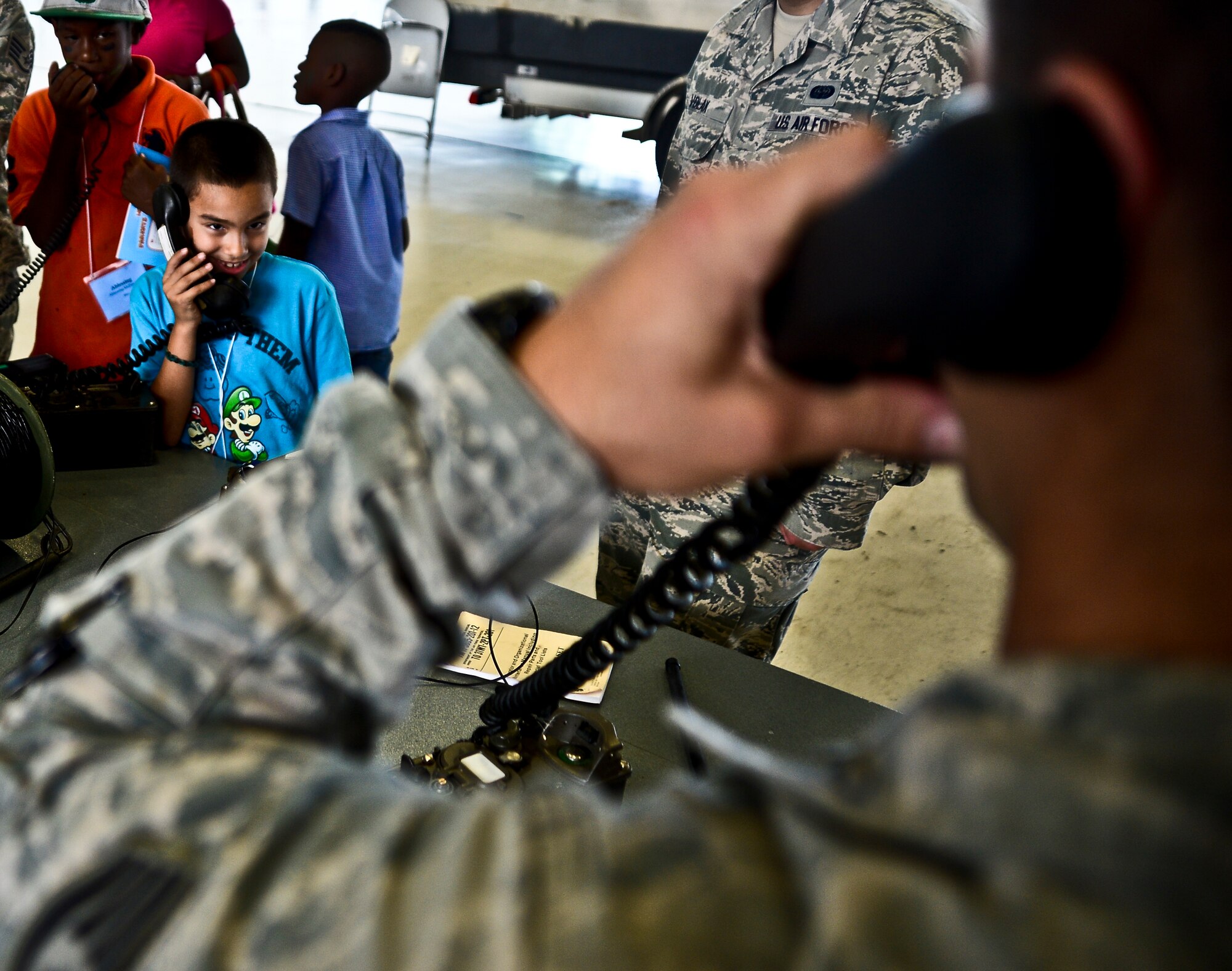 Children from the local community take turns talking back and forth through specialized combat communication gear with 6th Security Forces members during MacDill Air Force Base’s annual Bigs for a Day event, Oct. 21, 2013, at MacDill AFB, Fla. Dozens of children from the local community paired up with service members for a day of military “show-and-tell.” (U.S. Air Force photo by Staff Sgt. Brandon Shapiro/Released)
