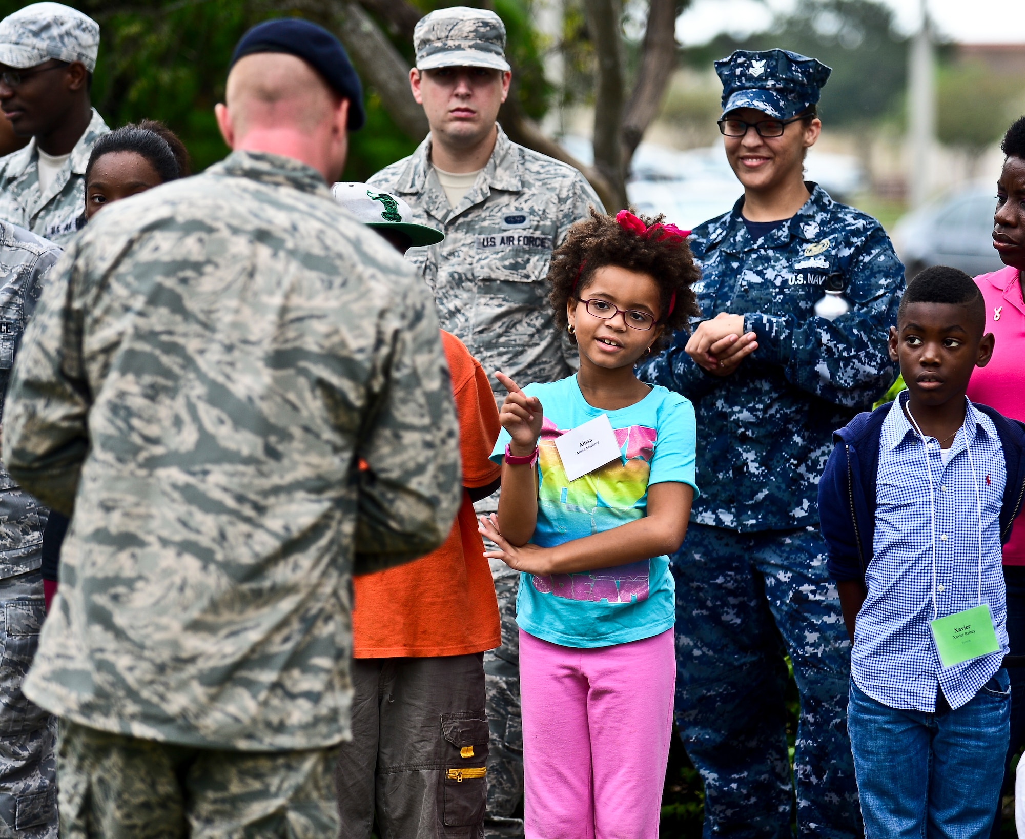 Little for a day, Alissa Martinez, asks military working dog trainer Staff Sgt. Shannon Hutto about how the military trains the working dogs during MacDill Air Force Base’s annual Bigs for a Day event, Oct. 21, 2013, at MacDill AFB, Fla. Dozens of children from the local community paired up with service members for a day of military “show-and-tell.” (U.S. Air Force photo by Staff Sgt. Brandon Shapiro/Released)