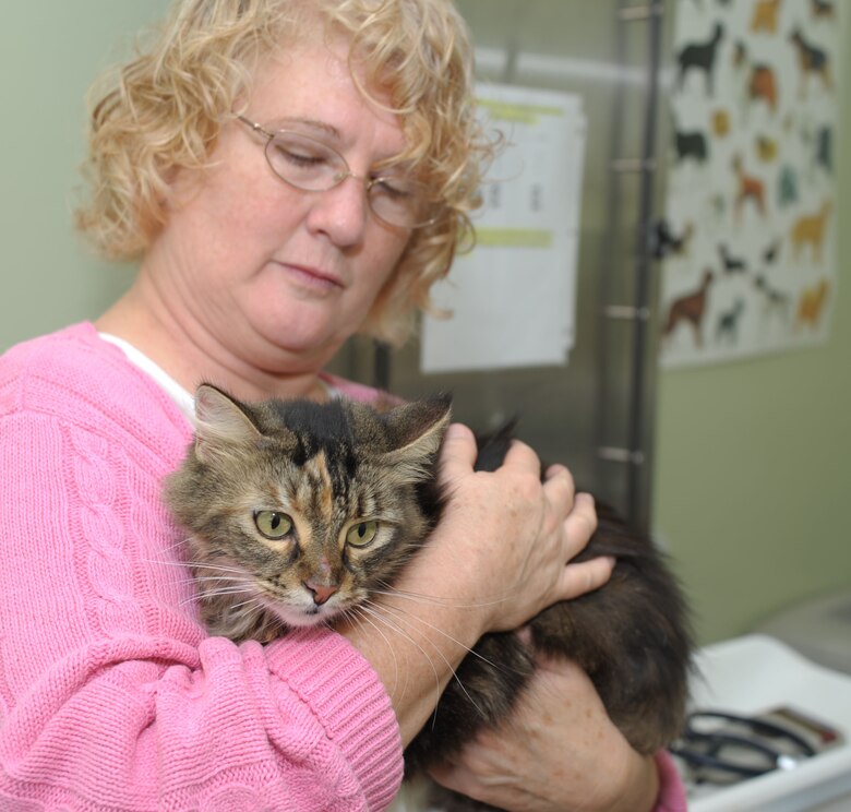 Karen Carter holds her cat Duchess as she waits for test results from the veterinarian Oct, 15, 2013 here. Duchess was taken to the vet two weeks ago after reuniting with her family. She ran away several weeks before that, and is currently recovering from injuries acquired during the run-away.  (U.S. Air Force photo by Senior Airman Natasha Stannard/Released)