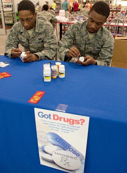 Airmen 1st Class Michael Canady, left, and Jordan McNair, 2nd Security Forces Squadron commander’s support staff, use permanent markers to mask the personal identification on prescription medication during Drug Take-Back Day on Barksdale Air Force Base, La., Oct. 23, 2013. Drug Take-Back Day is held every six months for Team Barksdale members to turn in their expired, unused and unwanted prescription drugs for destruction. (U.S. Air Force photo/Staff Sgt. Amber Corcoran)