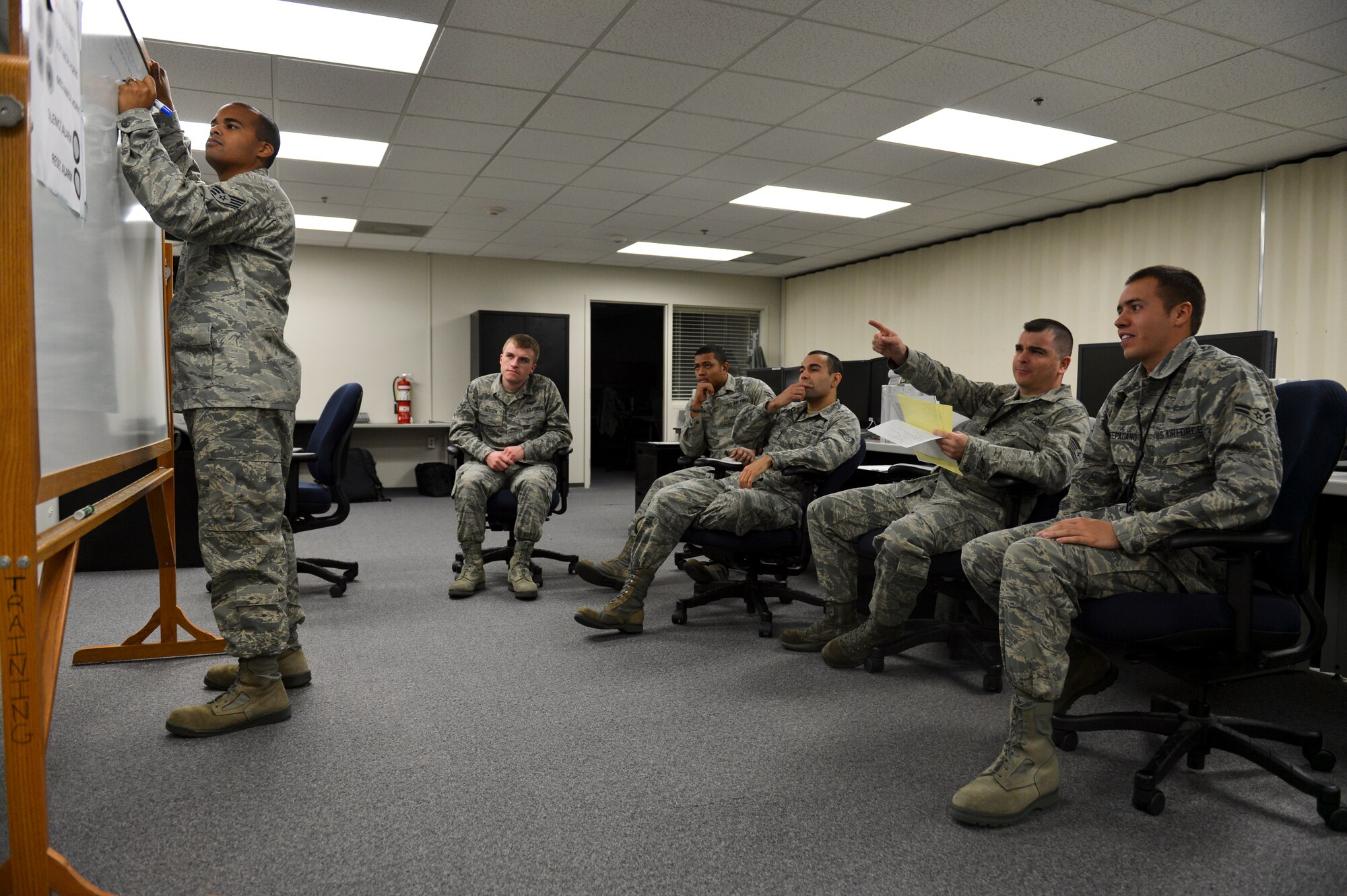 Members of the 2nd Space Warning Squadron debrief after completing scenarios in the Panther Challenge Oct. 10, 2013, at a training suite on Buckley Air Force Base, Colo. The 460th Space Wing hosted the first-ever Panther Challenge, a competition testing operational performance and crew knowledge, throughout October. (U.S. Air Force photo by Airman 1st Class Riley Johnson/Released)