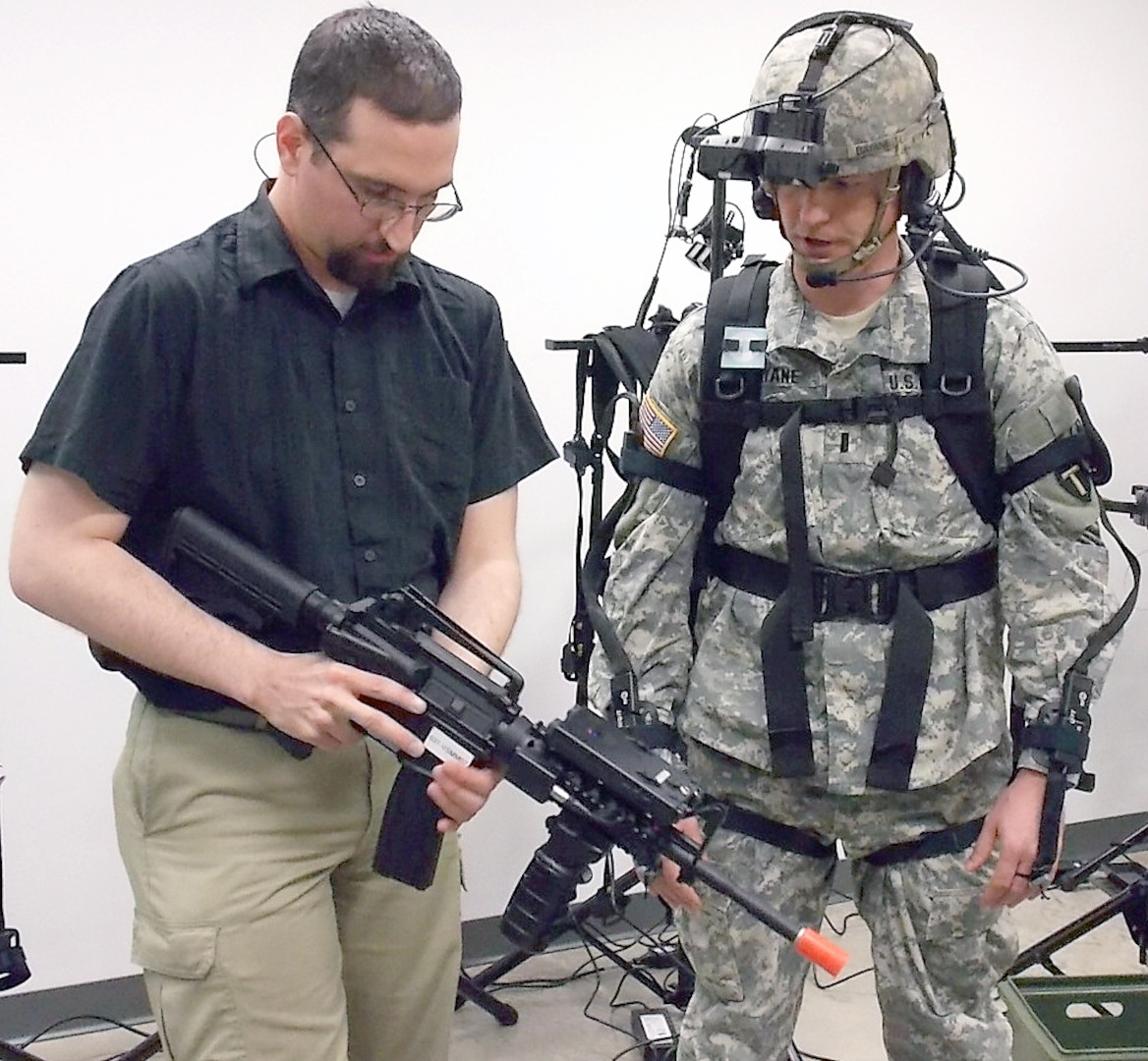 Dismounted Soldier Training System site lead Aaron Basmajian (left) demonstrates the operability of the simulated weapon system to a Soldier. (Army Photo Courtesy of HHC, Southern Training Division 75th Training Command)