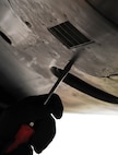 Senior Airman Kyle Sturdefant, 5th Aircraft Maintenance Squadron crew chief, tightens cover bolts after adding starter cartridges on one of the engines on a B-52H Stratofortressat Minot Air Force Base, N.D., Oct. 16. Starter cartridges are added to B-52 engines to speed up the process of takeoff.  (U.S. Air Force photo/Airman 1st Class Andrew Crawford)