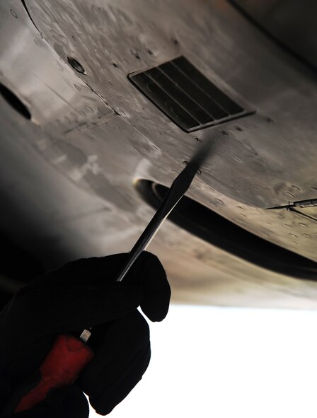 Senior Airman Kyle Sturdefant, 5th Aircraft Maintenance Squadron crew chief, tightens cover bolts after adding starter cartridges on one of the engines on a B-52H Stratofortressat Minot Air Force Base, N.D., Oct. 16. Starter cartridges are added to B-52 engines to speed up the process of takeoff.  (U.S. Air Force photo/Airman 1st Class Andrew Crawford)