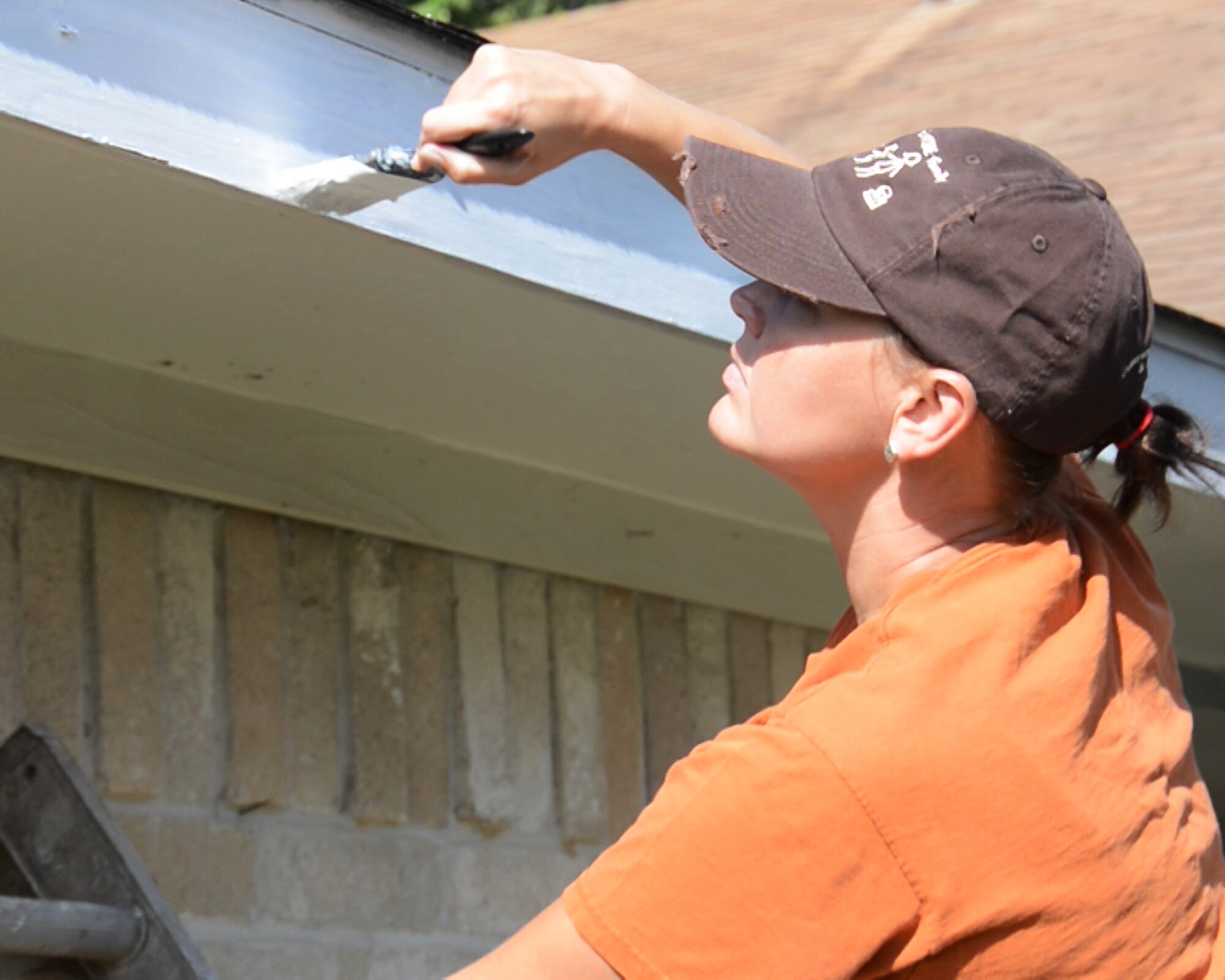 Tech. Sgt. Courtney Bosch,147th Reconnaissance Wing Medical Group, paints primer on a Vietnam veteran's home during a Rebuilding Together Houston project. Rebuilding Houston Together is a non-profit charity that helps low income disabled elderly people get emergency critical repairs done to their homes. National Guard Photo by Master Sgt. Sean Cowher