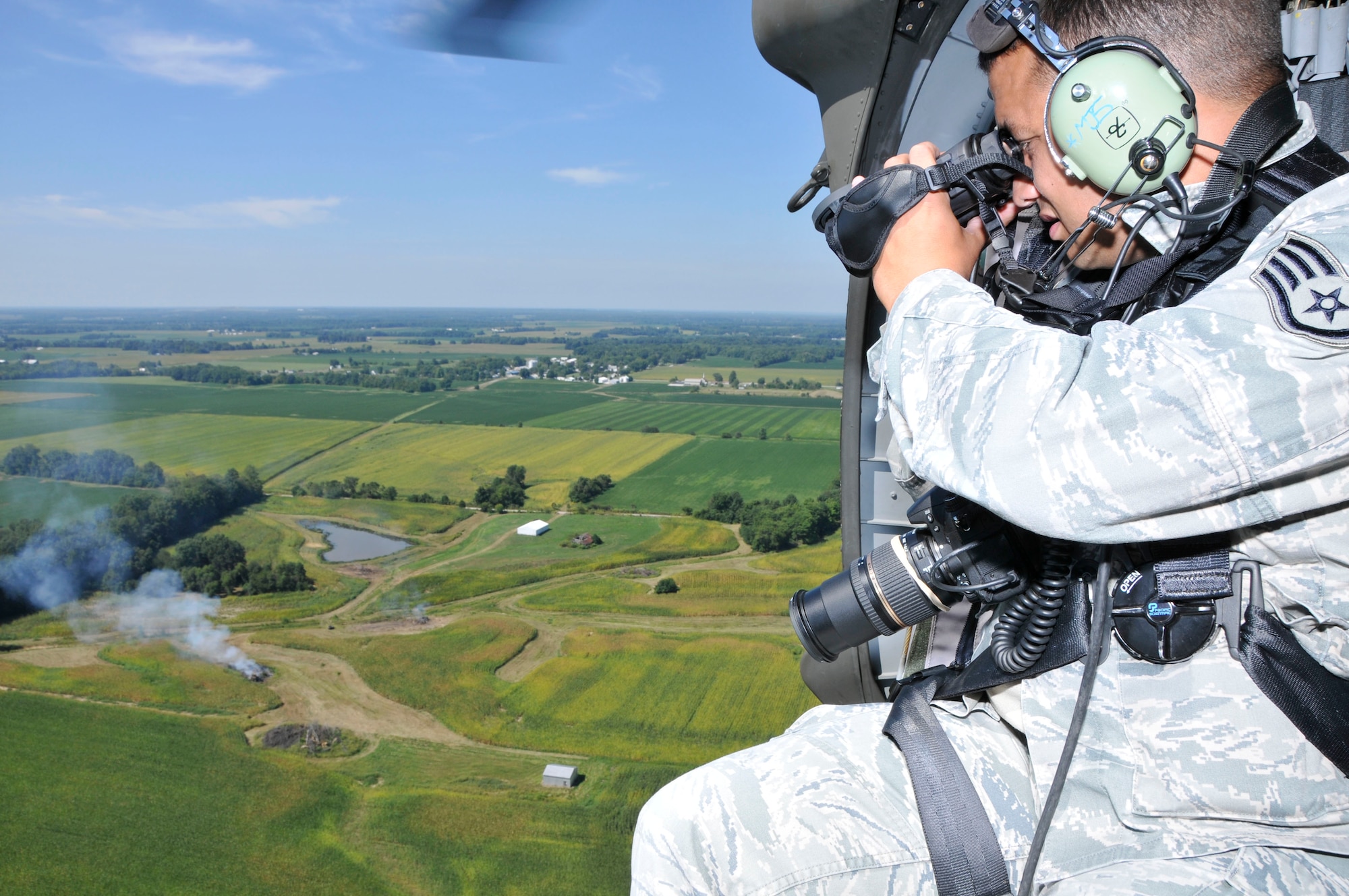 U.S. Air Force Staff Sgt. Kevin Arnett, with the 181st Intelligence Wing, Indiana Air National Guard, looks through an Infrared Camera (IR) at burn piles in Clay County while on board a U.S. Army UH-60 Black Hawk from Shelbyville, Ind., Sep. 4, 2013.  (U.S. Air National Guard photo by Senior Master Sgt. John S. Chapman/Released)