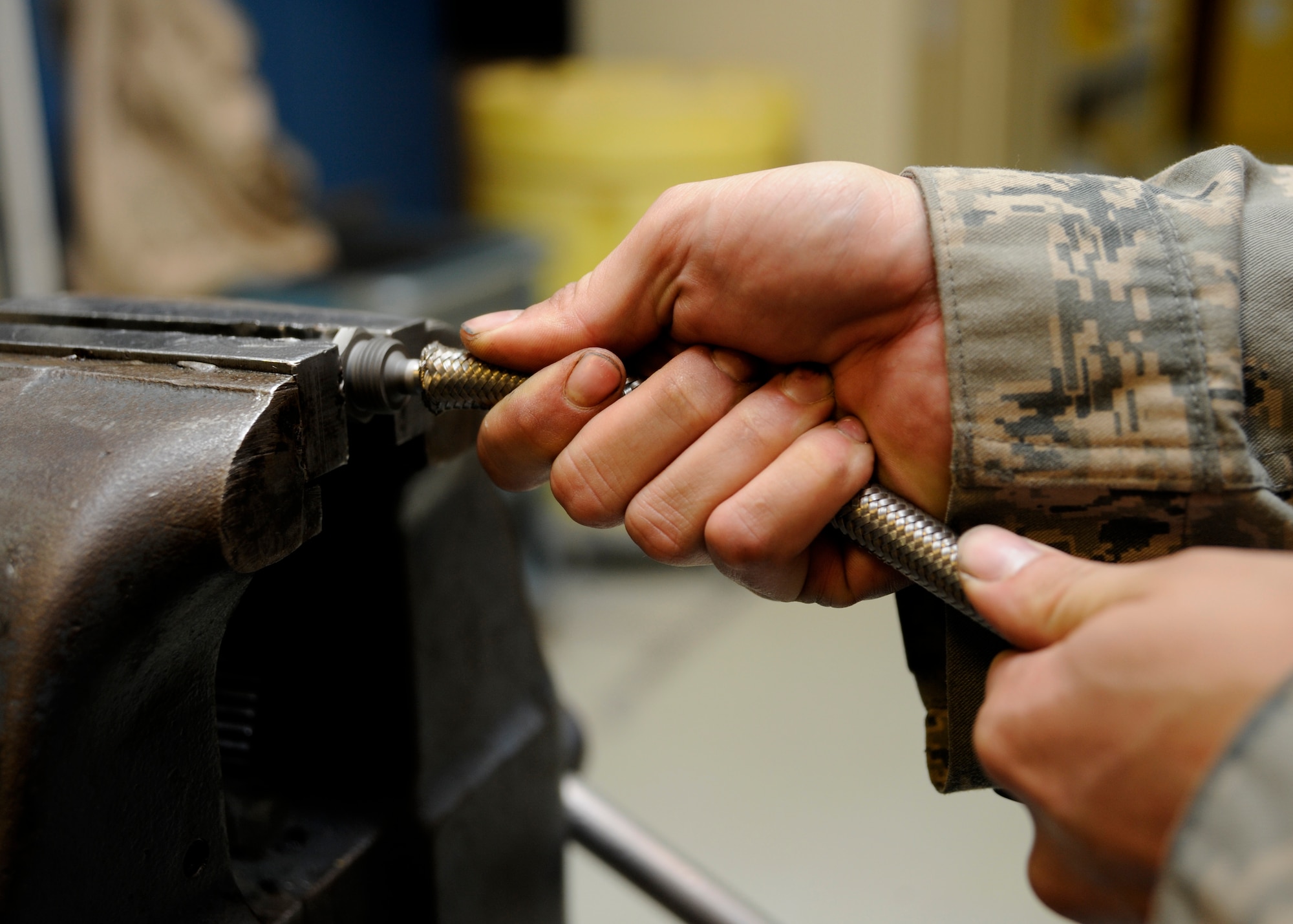Senior Airman Wil Parker uses a vise to assemble a high-pressure Teflon hose at the 379th Air Expeditionary Wing in Southwest Asia, Oct. 15, 2013. Beyond support to KC-135 Stratotankers, the 379th Expeditionary Maintenance Squadron hydraulics section supports other weapon systems here by testing and fabricating hydraulic hoses. Parker is a 379th EMXS hydraulics section technician deployed from Kadena Air Base, Japan, and hails from Merritt Island, Fla. (U.S. Air Force photo/Senior Airman Bahja J. Jones) 