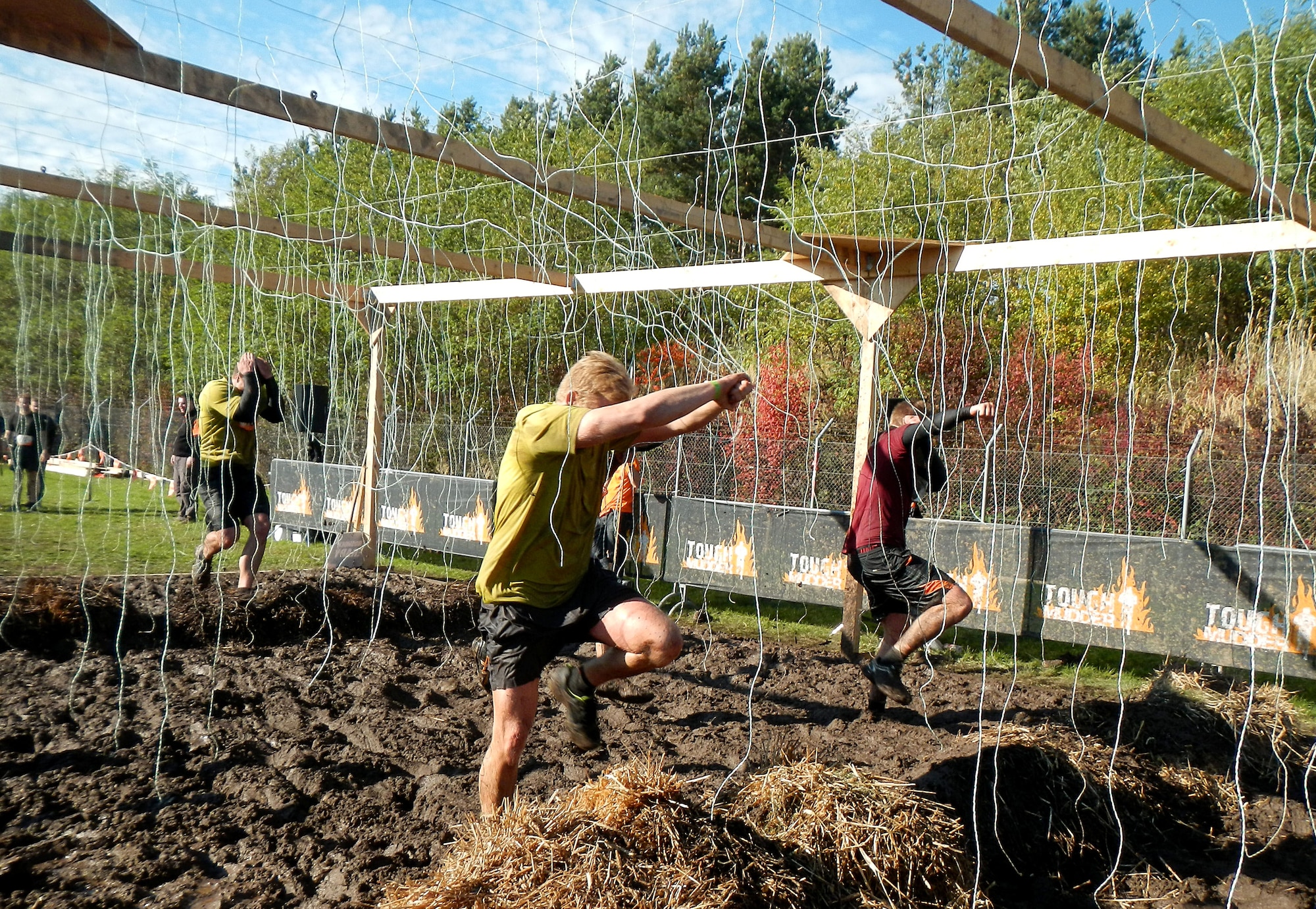 Challengers race through an electric obstacle Oct. 19, 2013, during the Tough Mudder in Berlin, Germany. During the electric obstacle, participants must dodge hay bales, deep mud and electrified wires. (U.S. Air Force photo/Senior Airman Michael Battles)