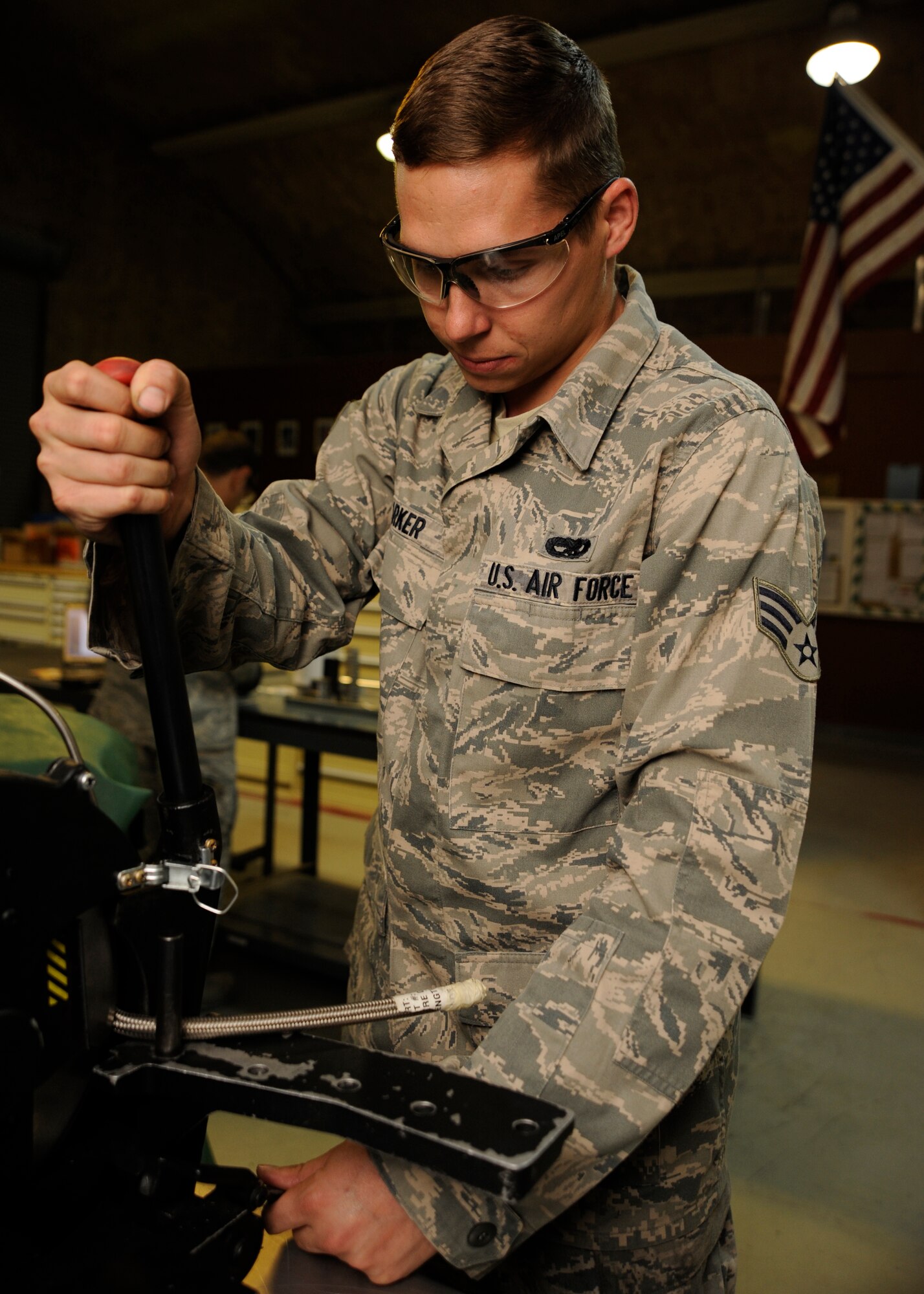 Senior Airman Wil Parker uses a hose cutting machine to cut a high-pressure Teflon hose at the 379th Air Expeditionary Wing in Southwest Asia, Oct. 15, 2013. Beyond support to KC-135 Stratotankers, the 379th Expeditionary Maintenance Squadron hydraulics section supports other weapon systems here by testing and fabricating hydraulic hoses. Parker is a 379th EMXS hydraulics section technician deployed from Kadena Air Base, Japan, and hails from Merritt Island, Fla. (U.S. Air Force photo/ Senior Airman Bahja J. Jones) 