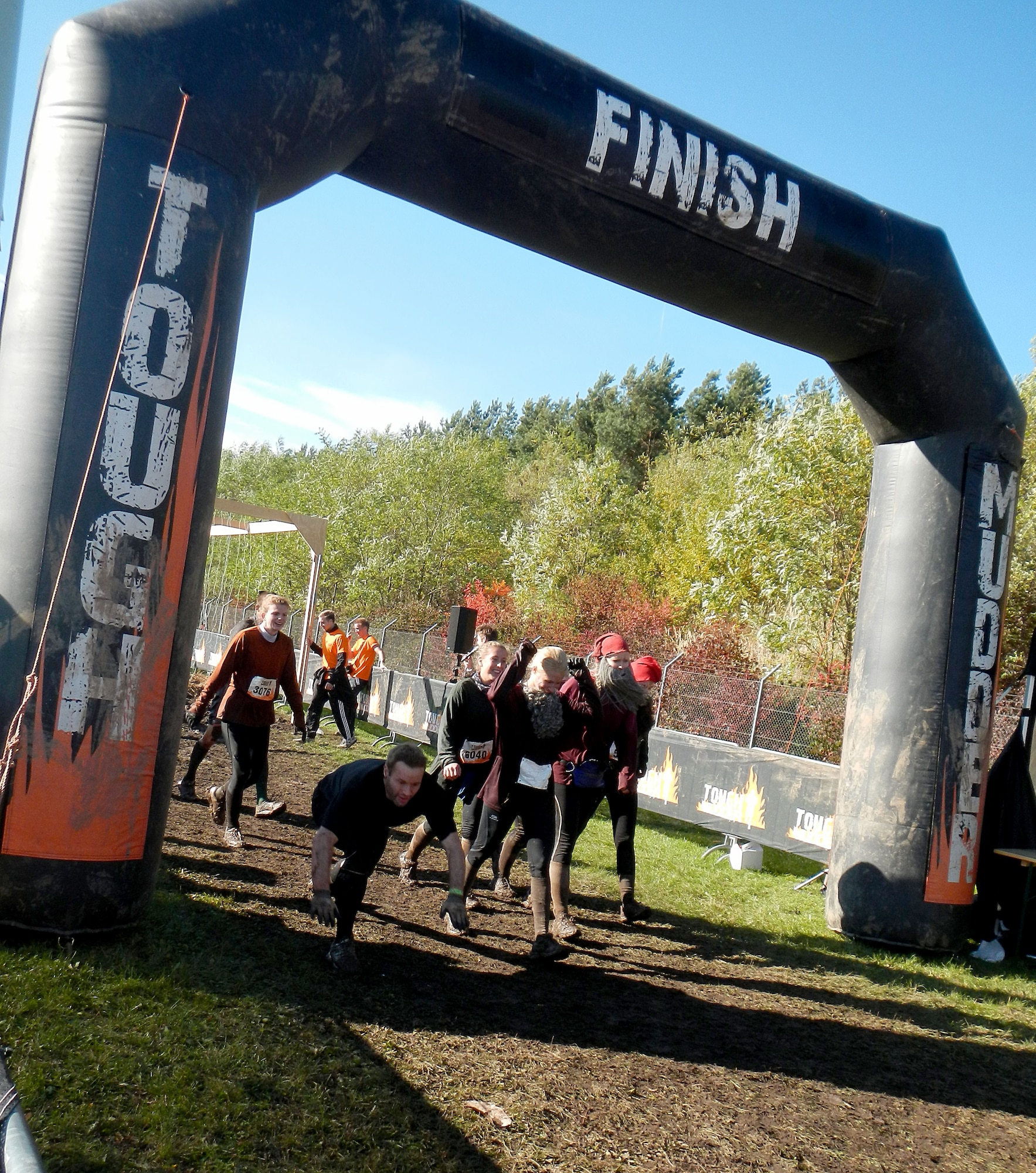 Challenge participants cross the finish line Oct. 19, 2013, during the Tough Mudder in Berlin, Germany. The challenge consisted of a 13-mile course filled with 30 obstacles designed by British Special Forces that test a participant’s strength, stamina, mental grit and camaraderie. (U.S. Air Force photo/Senior Airman Michael Battles)