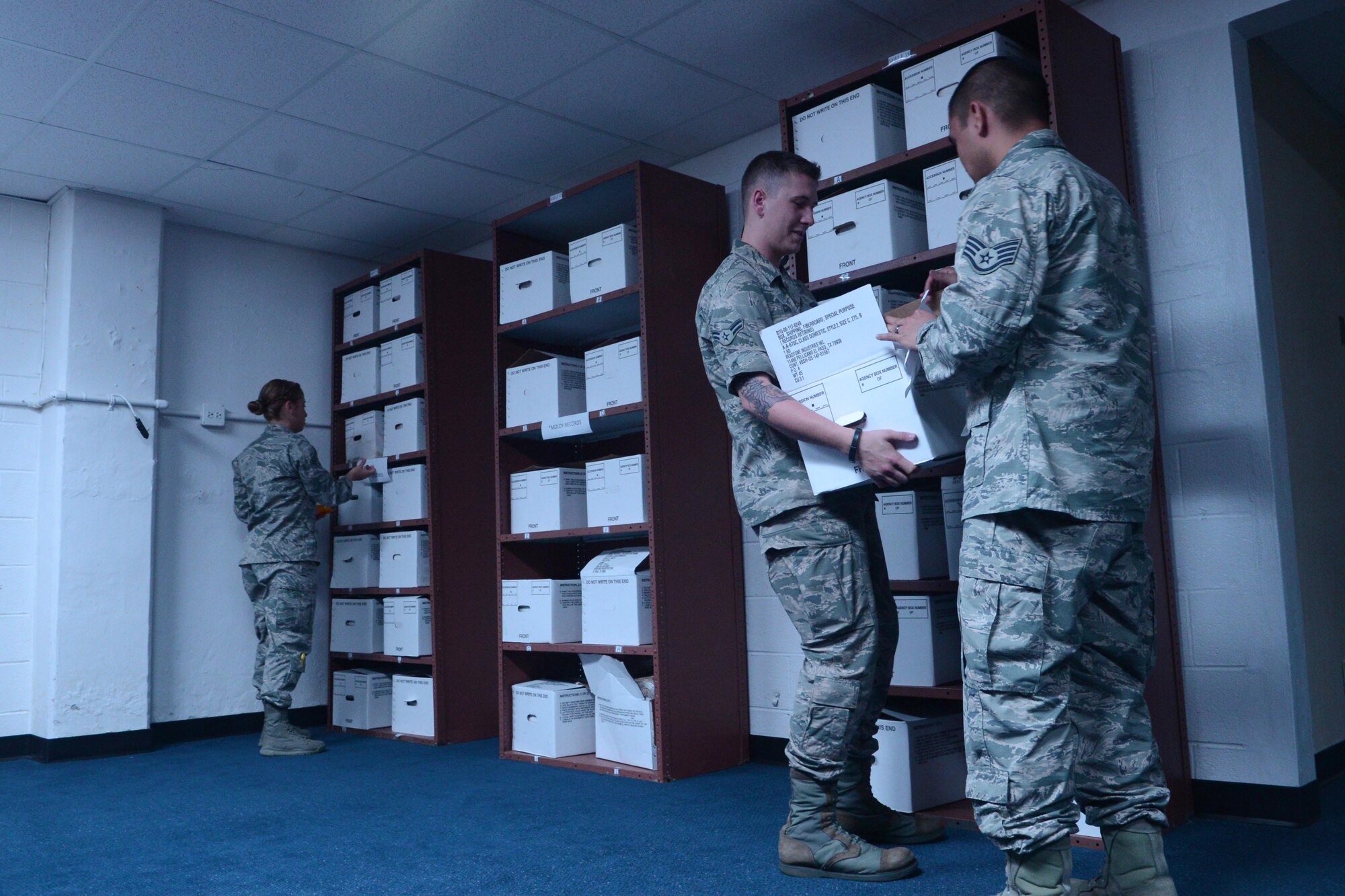 (From left) Airman 1st Class Paola Ledesma-Seijo, 36th Communications Squadron base records manager, Airman 1st Class Presley Griffith, 36th CS base staging manager, and Staff Sgt. Fredy Imanuel, 36th CS base records manager, take down boxes for destruction Sept. 27, 2013, on Andersen Air Force Base, Guam. Base records managers store, organize and assist with records requests for Andersen.(U.S. Air Force photo by Airman 1st Class Emily A. Bradley/Released)