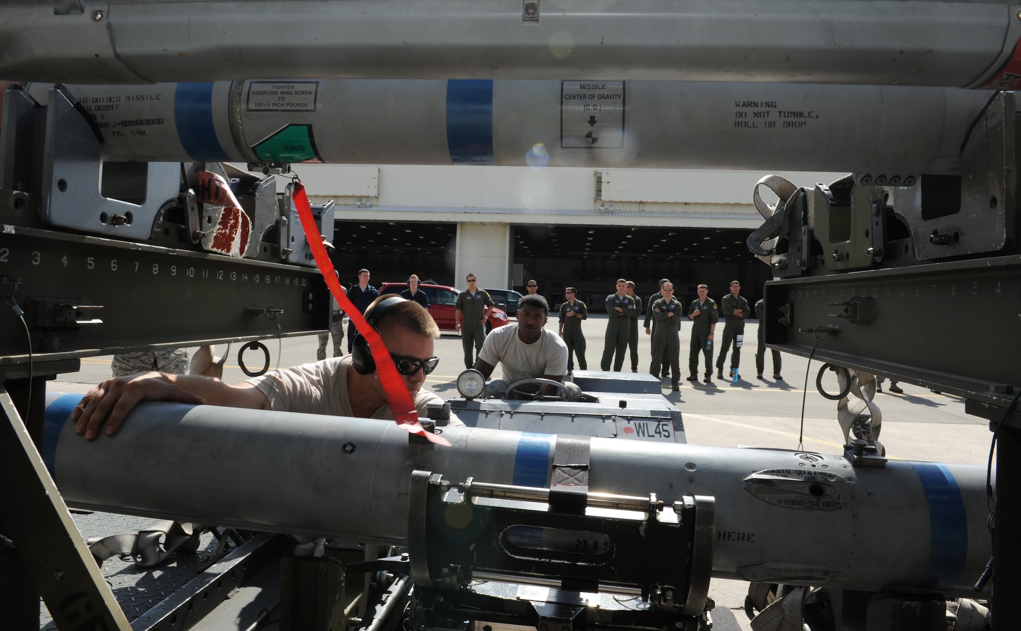 U.S. Air Force Staff Sgt. Wil Hart, (left), 44th Aircraft Maintenance Unit load crew team chief, guides Senior Airman Armanni Thompson, 44th Aircraft Maintenance Unit weapons load crew member, as they work together to connect a missile to an F-15 Eagle during a weapons load competition on Kadena Air Base, Japan, Oct.18, 2013. Weapons load competitions allow load crews to showcase their skills and demonstrate the efficiency of the team. (U.S. Air Force photo by Airman 1st Class Keith James)
