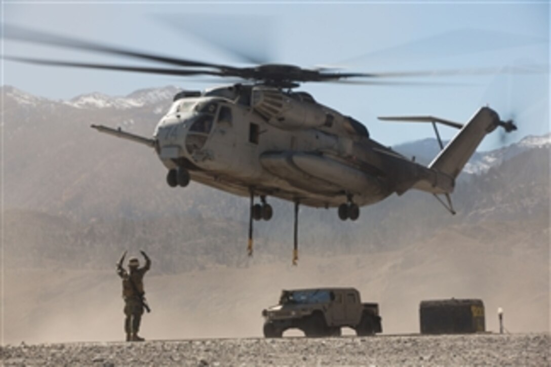 A U.S. Marine directs the pilots of a CH-53E Super Stallion helicopter after releasing a Humvee at the Marine Corps Mountain Warfare Training Center in Bridgeport, Calif., on Oct. 18, 2013.  The Super Stallion, assigned to Marine Heavy Helicopter Squadron 466, delivered the Humvee as part of Mountain Exercise 6-13.  
