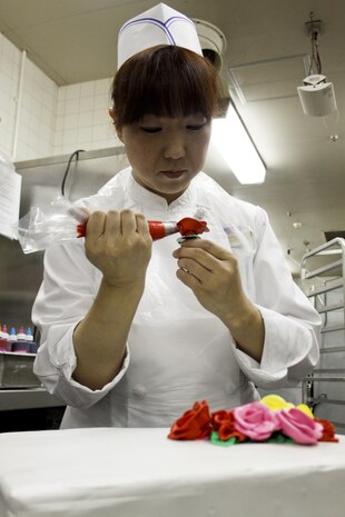 Kaori Nohara, a Club Iwakuni chef, uses a piping bag to make roses to decorate a birthday cake for a customer at Club Iwakuni, Marine Corps Air Station Iwakuni, Japan, June 21, 2013. Nohara has been baking for nearly eight of the 13 years she has worked at the club.