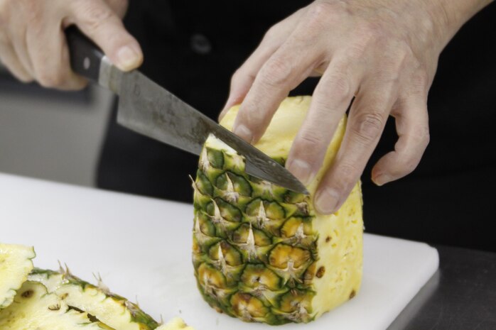 Senji Shoya, Club Iwakuni supervisor, prepares a pineapple for an eating display for an upcoming party at Club Iwakuni at Marine Corps Air Station Iwakuni, Japan, June 27, 2013.