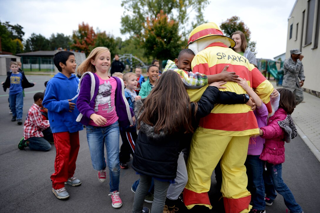 Children rush to meet Sparky the Fire Dog as part of Fire Prevention Week Oct. 9, 2013, at Spangdahlem Air Base, Germany. Sparky and his firefighting companions reminded children to be safe and that firefighters are their friends. (U.S. Air Force photo/Airman 1st Class Kyle Gese)