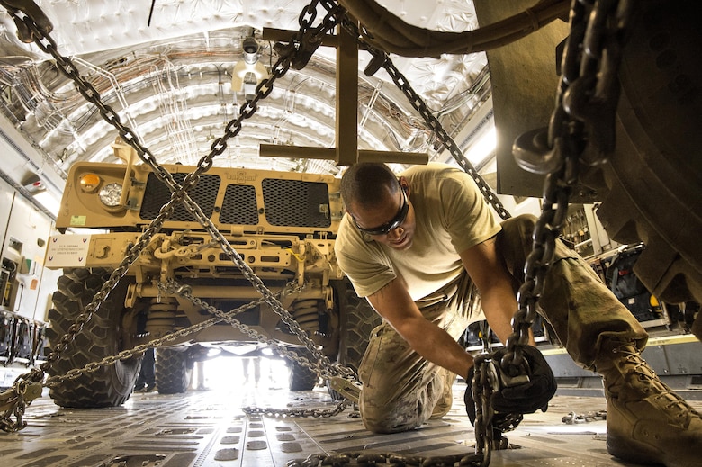 Staff Sgt. Ryan Vanterpool chains down a mine-resistant, armored-protective vehicle, known as an MRAP, on a C-17A Globemaster III Oct. 2, 2013, at Bagram Airfield, Afghanistan. Bagram has become a major hub for retrograde operations out of Afghanistan. The 455th Expeditionary Aerial Port Squadron special handling section pushed 4.2 million pounds of retrograde equipment during the month of September. Vanterpool, a Honolulu, Hawaii native, is deployed from Joint Base McGuire-Dix-Lakehurst, N.J. Vanterpool is a 455th EAPS aerial porter. (U.S. Air Force photo/Master Sgt. Ben Bloker)
