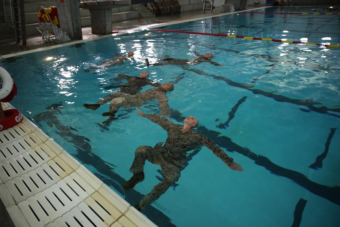 Recruits tread water during a portion of their Marine Corps Water Survival Training Program qualification. Recruits are expected to tread water for four mintues, using the techniques that were taught to them in order to pass the event.