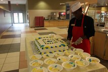 Lance Cpl. Asia Brown, Headquarters and Headquarters Squadron food service specialist, cuts the Navy birthday cake at the mess hall aboard Marine Corps Air Station New River Oct. 11.
