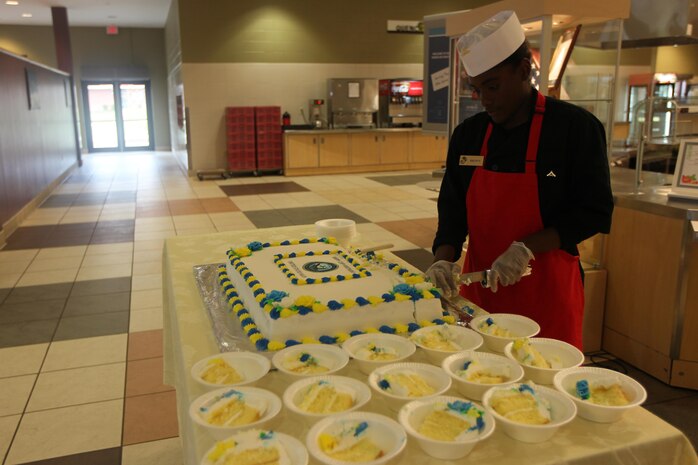 Lance Cpl. Asia Brown, Headquarters and Headquarters Squadron food service specialist, cuts the Navy birthday cake at the mess hall aboard Marine Corps Air Station New River Oct. 11.

