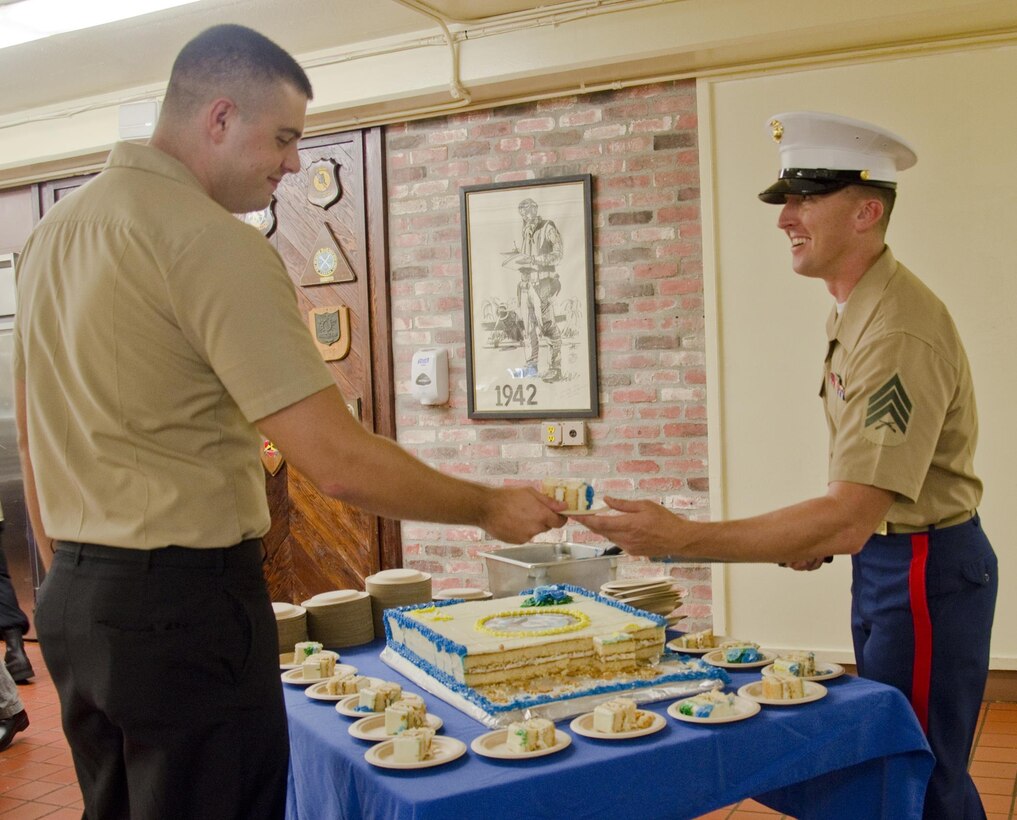 Sgt. Christopher Womack, a food service specialist at the Anderson Hall Dining Facility serves cake during a special birthday lunch at the facility, Oct. 18, 2013. The Navy celebrated its 238th birthday Oct. 13, 2013. Anderson Hall staff served a special meal including steak, crab legs and birthday cake. (U.S. Marine Corps photo by Kristen Wong)