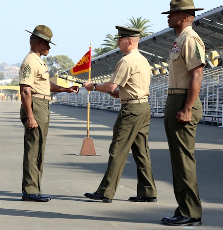 Brig. Gen. James W. Bierman passes the sword of office to Sgt. Maj. James K. Porterfield during a post and relief ceremony for Marine Corps Recruit Depot San Diego and Western Recruiting Region on Shepherd Field, Oct. 25. The ceremonial passing of the sword of office represents the passing of duties and accomplishments from one sergeant major to another. Daniels retires after 31 years of service and Porterfield assumes duties as sergeant major of MCRD San Diego and the WRR. During the ceremony, both sergeants major thanked the Marines who they have served with and acknowledged all of the support that they have received from their families, friends and community. 