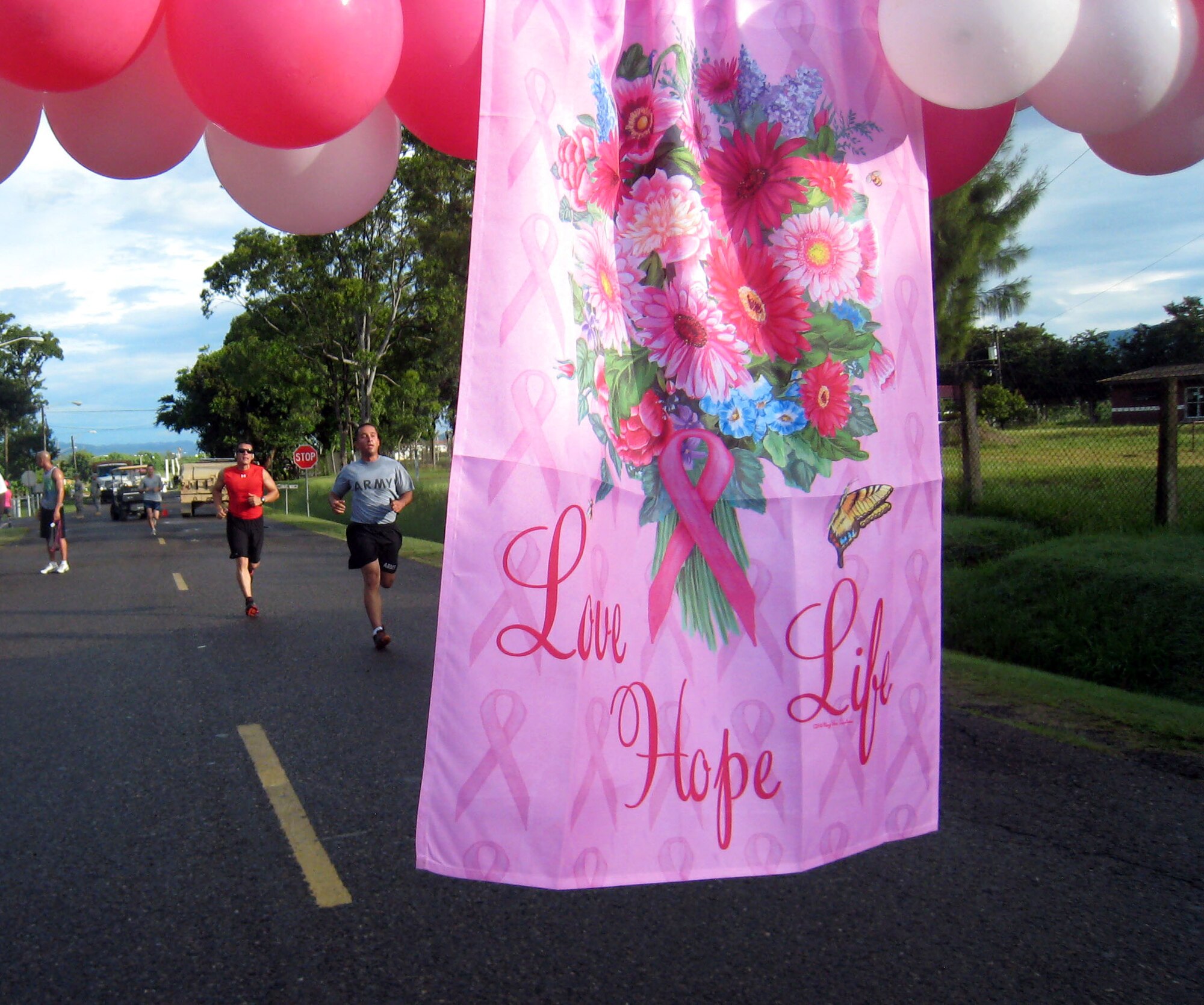 Runners close in on the finish line of the first-ever Soto Cano Air Base "Fight Against Breast Cancer" six-kilometer run, Oct. 25, 2013.  The event was organized by the 612th Air Base Squadron, and raised more than $1,000 in funding that was donated to breast cancer research through the Combined Federal Campaign.  (U.S. Air Force photo by Capt. Zach Anderson)