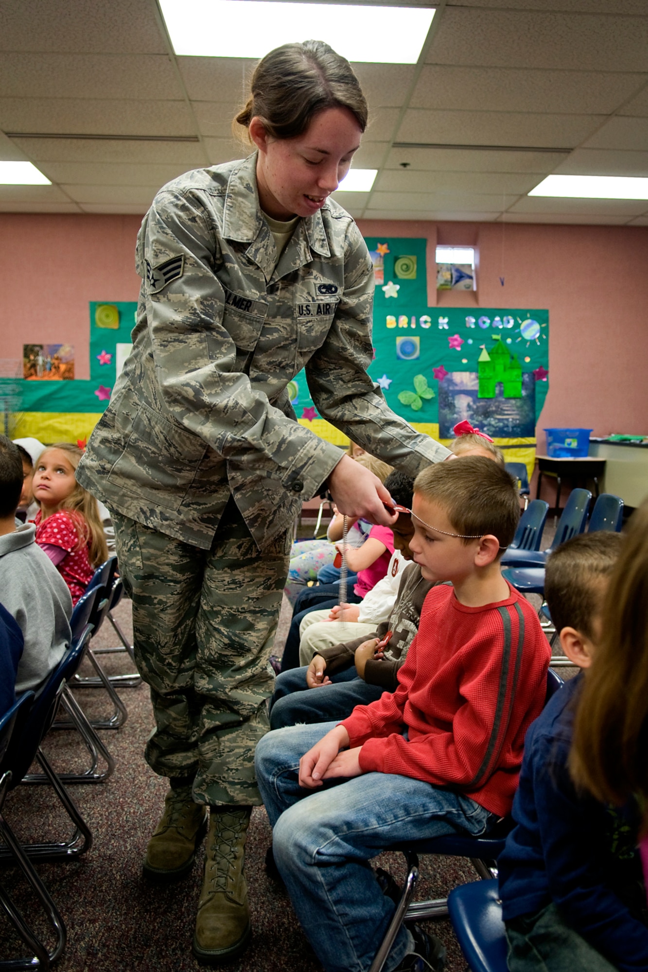 Senior Airman Alina Palmer, 434th Aircraft Maintenance Squadron KC-135 crew chief; places a "Drug Free" dog tag around the neck of Alan Cooper, a kindergarten student at Pipe Creek Elementary, during a special presentation teaching students at the school to say no to drugs and alcohol Oct. 22. Several Airmen from Grissom Air Reserve Base, Ind., were led by Gary Flook, 434th Air Refueling Wing drug demand specialist, as they talked to kids at Pipe Creek in Peru, Ind., and North Miami Elementary in Denver, Ind., about the dangers of drugs and how to deal with peer pressure. (U.S. Air Force photo/Tech. Sgt. Mark R. W. Orders-Woempner)

